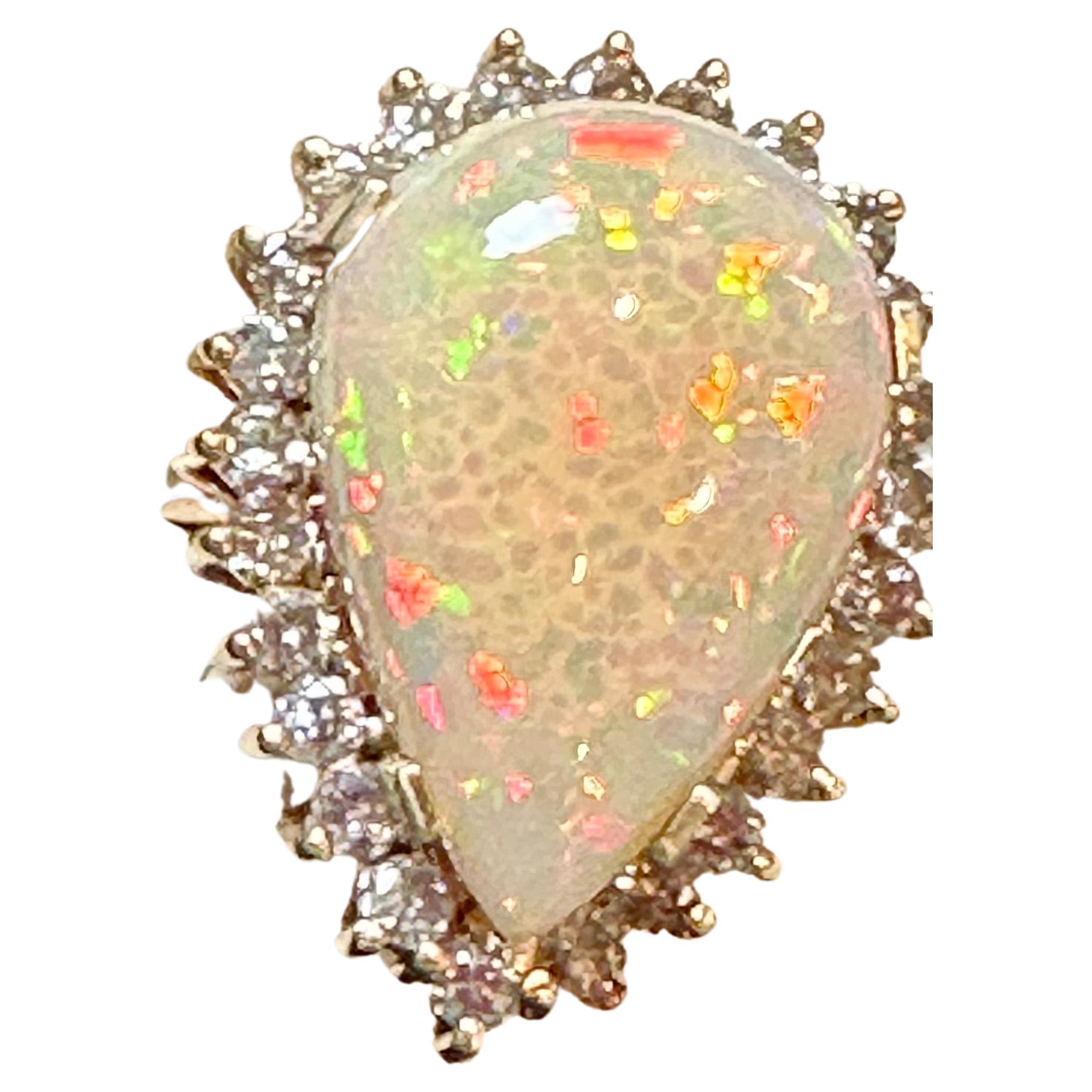 Introducing a timeless cocktail ring featuring a stunning 30-carat pear-shaped opal and diamond. This ring showcases a natural opal with mesmerizing colors, exhibiting excellent quality and clarity. The opal's sizable tear drop shape enhances its