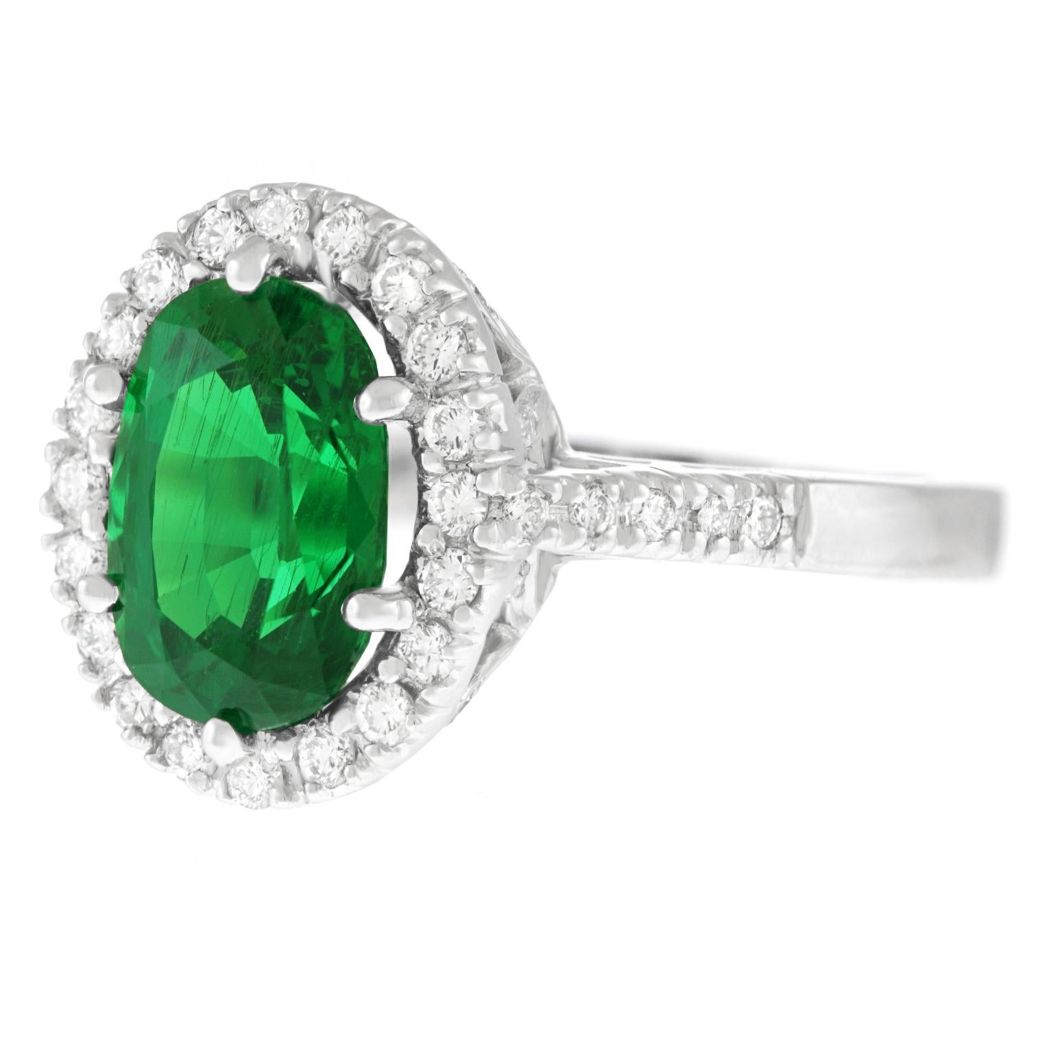 Circa 2000, 18k, American.  This gorgeous ring perfectly balances timeless elegance with contemporary style. Its vibrant 3.00 carat tsavorite garnet is surrounded by 1.0 carats total weight of brilliant white diamonds (G color, VS clarity).