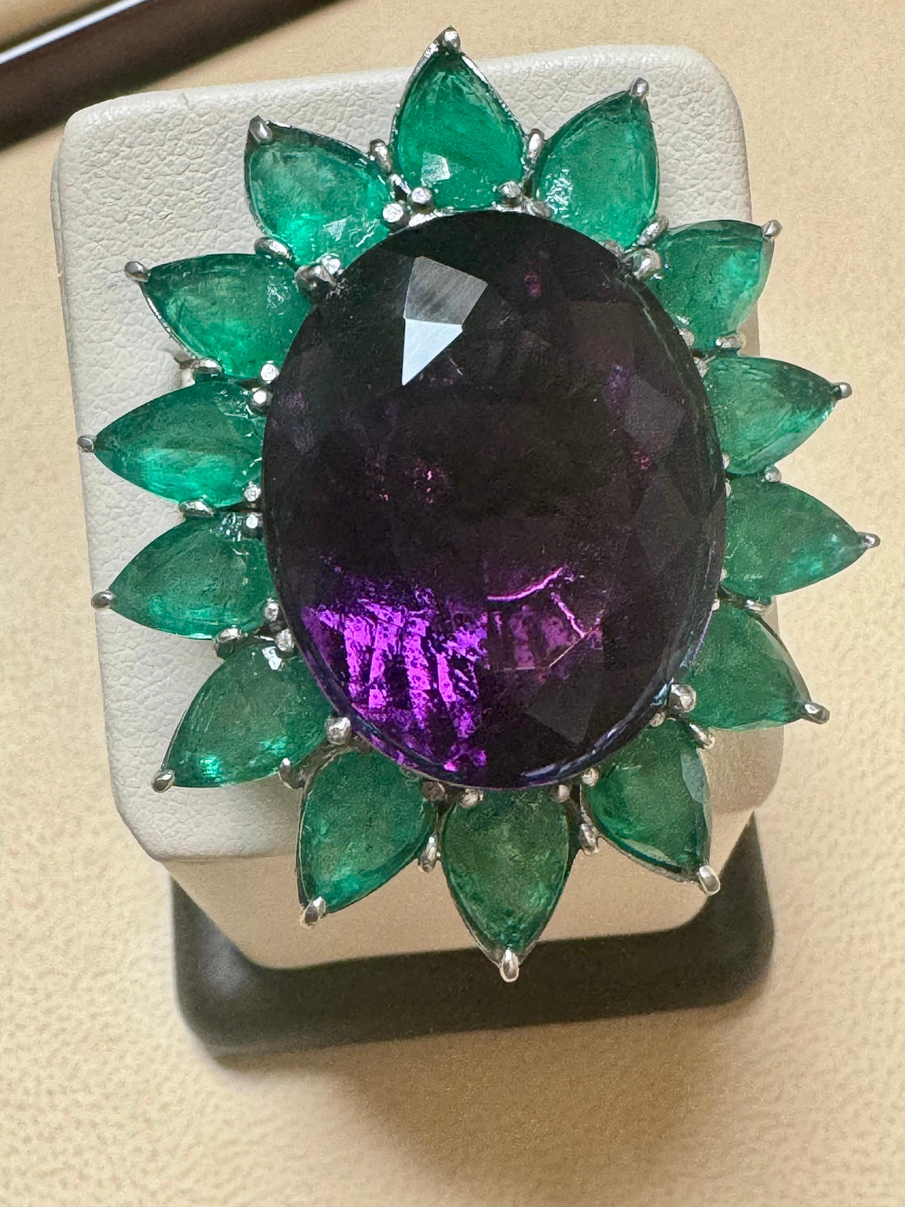 Approximately 30 Ct Oval Amethyst & 25 Ct Emerald Large Cocktail Ring in Platinum, 32 gm, Size 6. This beautiful cocktail ring features a large, high-quality oval amethyst weighing around 30 carats, boasting exceptional color and clarity in a