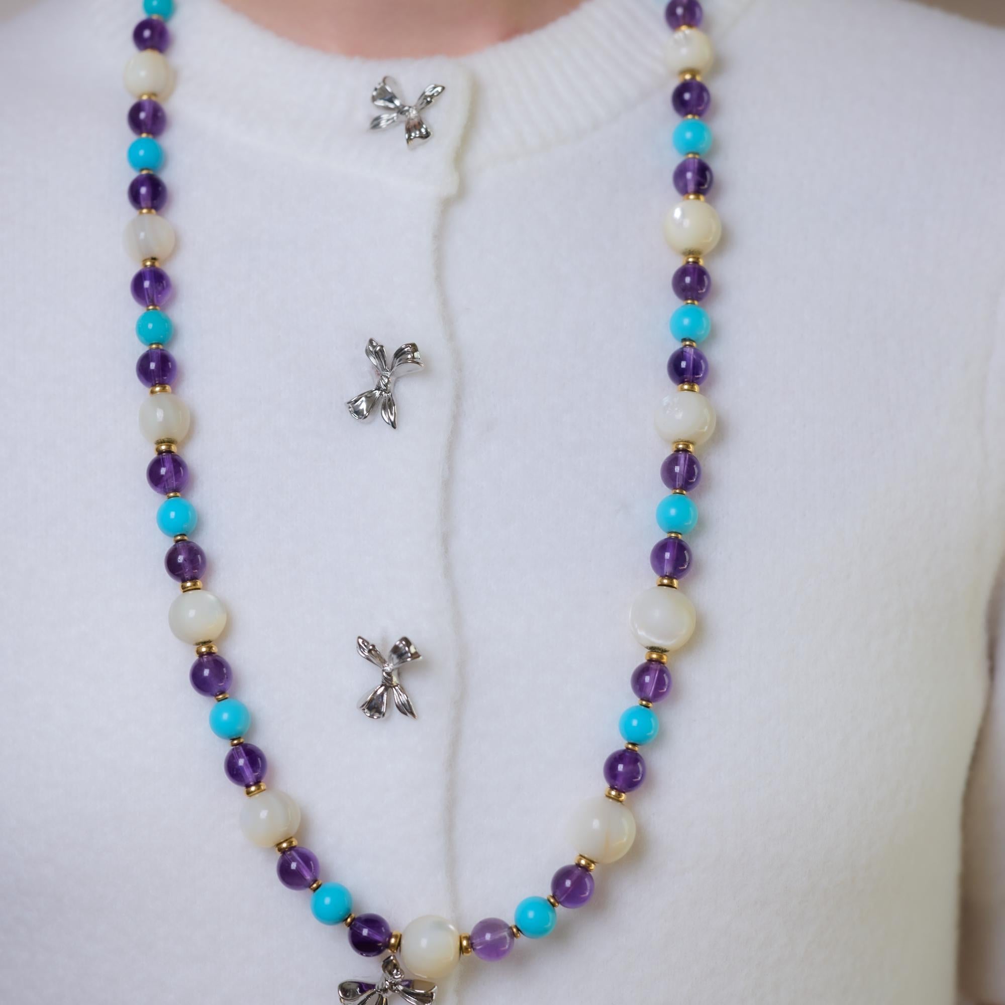 This vintage 30-inch Italian bead necklace features 15 luminous mother-of-pearl beads (approximately 15.85mm-12.07mm), accented by 30 rich amethyst and 14 vibrant turquoise beads (approximately 10.20mm). Set in 18k yellow gold, this striking piece