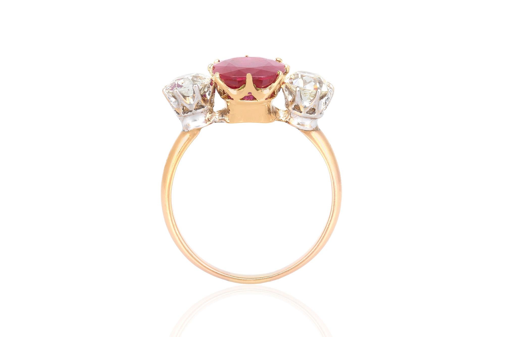 Estate ring finely crafted in 18K yellow gold features an oval shaped 3.00 carat Burma Ruby. The center stone is flanked by two round brilliant cut diamonds, weighing a total of 2.25 carat. Circa 1950's.