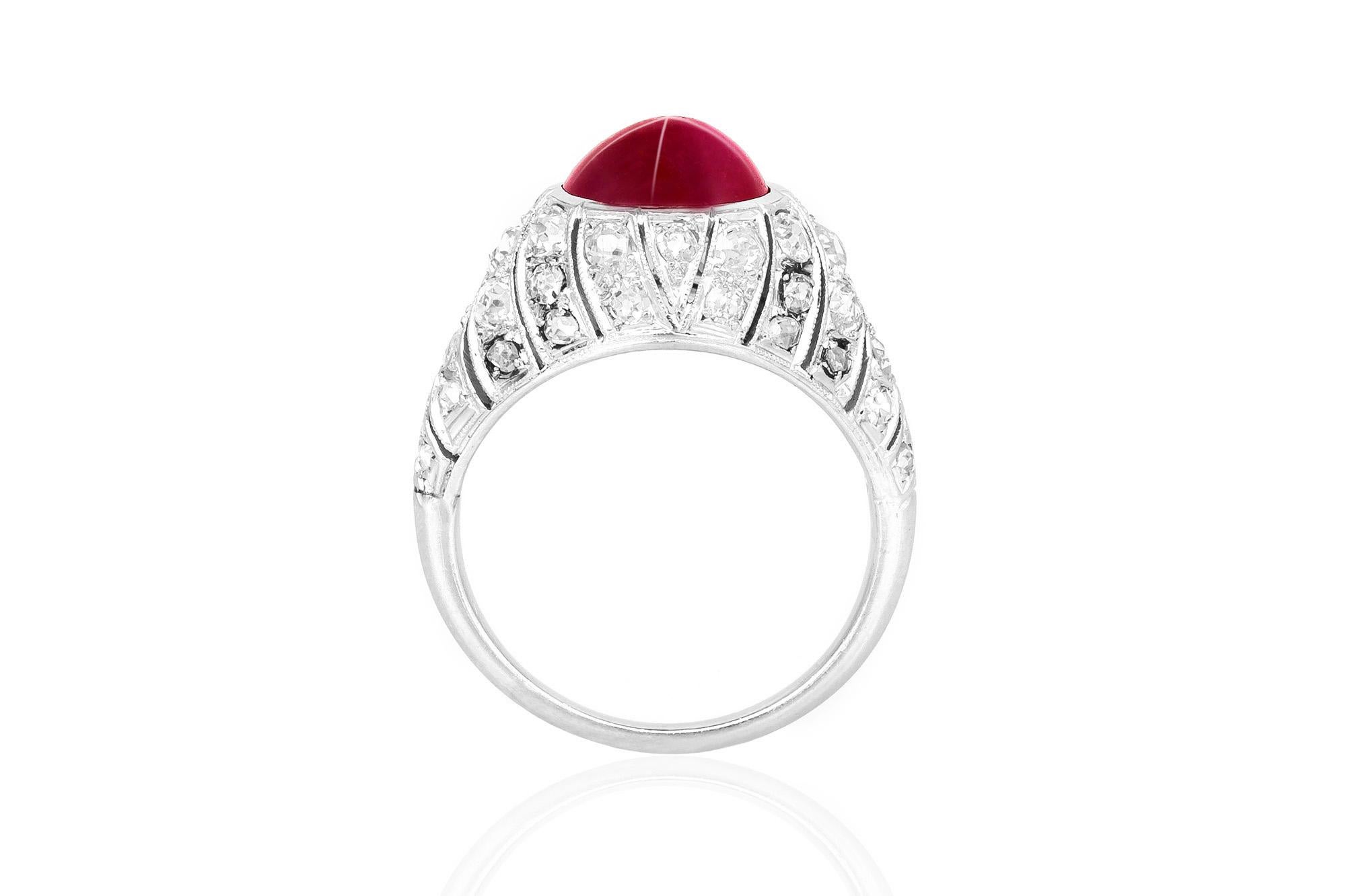 Antique Art Deco ring, finely crafted in platinum with a 3.00 carat cabochon ruby at the center. Accented with 1.60 carats of old European cut diamonds and millegrained geometric segments. Circa 1930's.