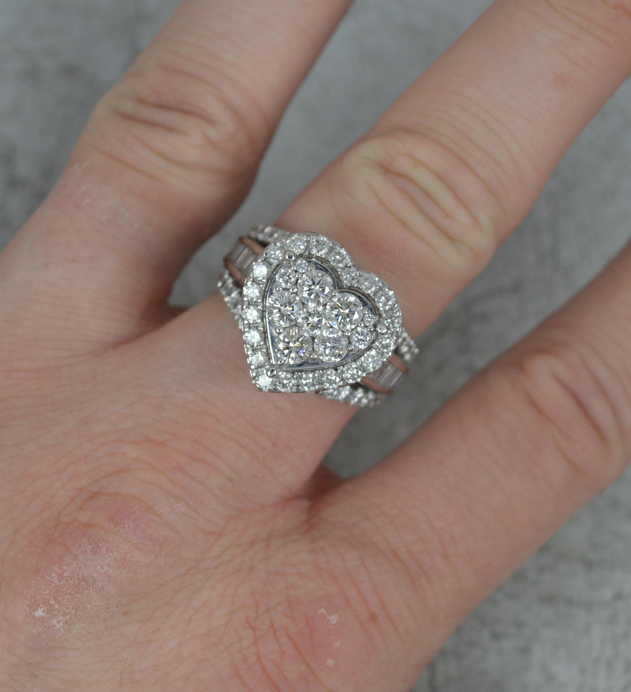 A striking diamond cluster ring.
Solid 9 carat white gold.
Heart shape cluster, 16mm x 17mm. Set with round brilliant cut diamonds with round and baguette cut diamonds in three rows to the shoulders.
Total carat weight 3.00 as confirmed to shank.