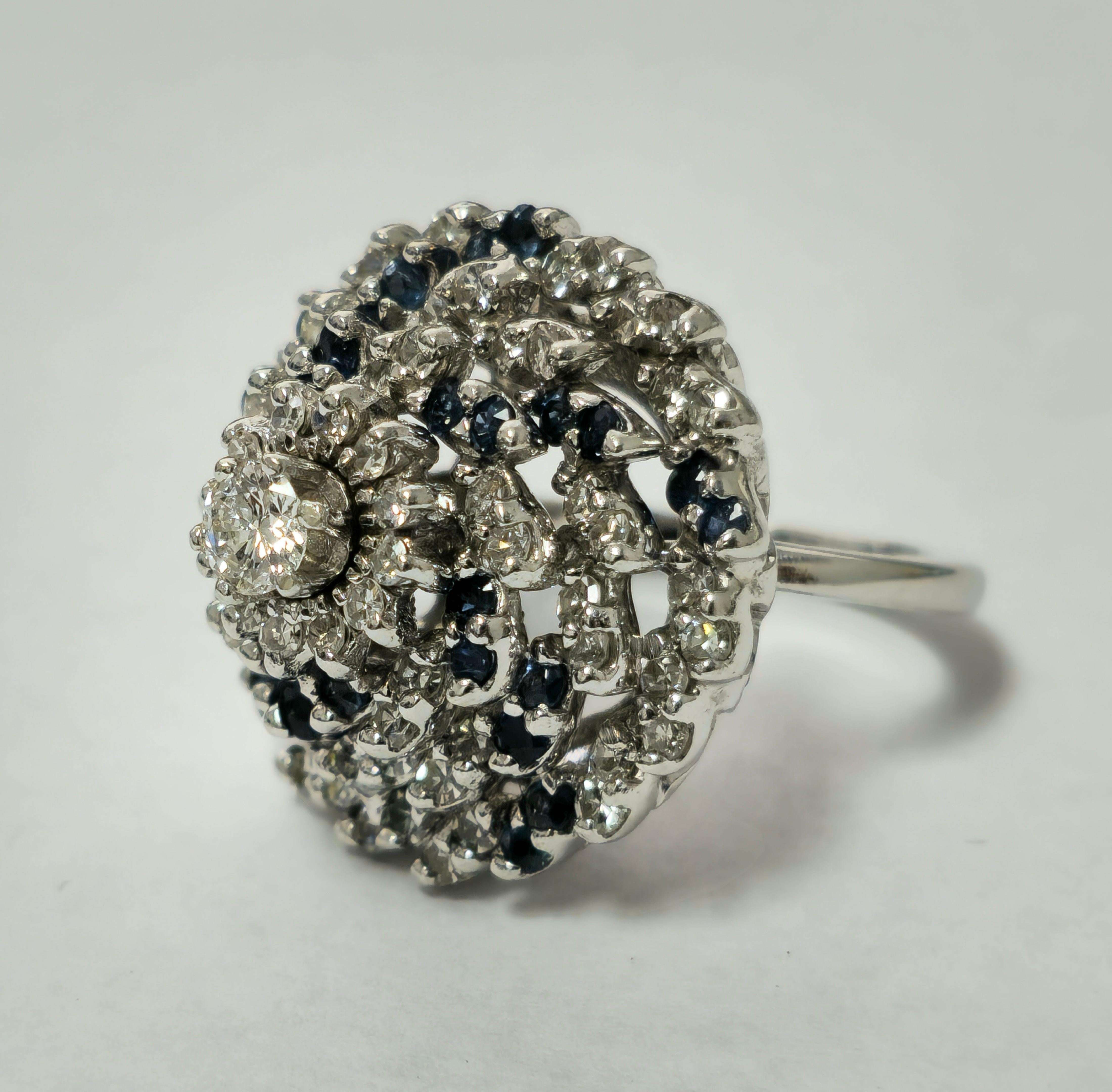Adorned with a poetic swirl of cornblue sapphires and shimmering diamonds, this boucle-style ring captures the fluidity of a sparkling cocktail swirl. With VVS clarity and F color, every diamond radiates natural brilliance, complemented by a blue