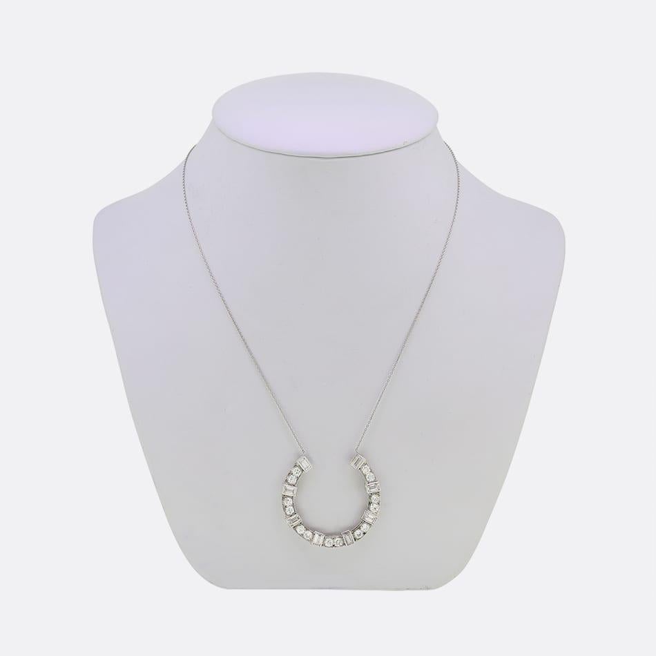 Questa è una collana di diamanti a ferro di cavallo. La collana presenta otto diamanti taglio baguette e quattordici diamanti rotondi in un motivo a ferro di cavallo realizzato in platino e sospeso su una sottile catena in platino. 

Condit: Usato