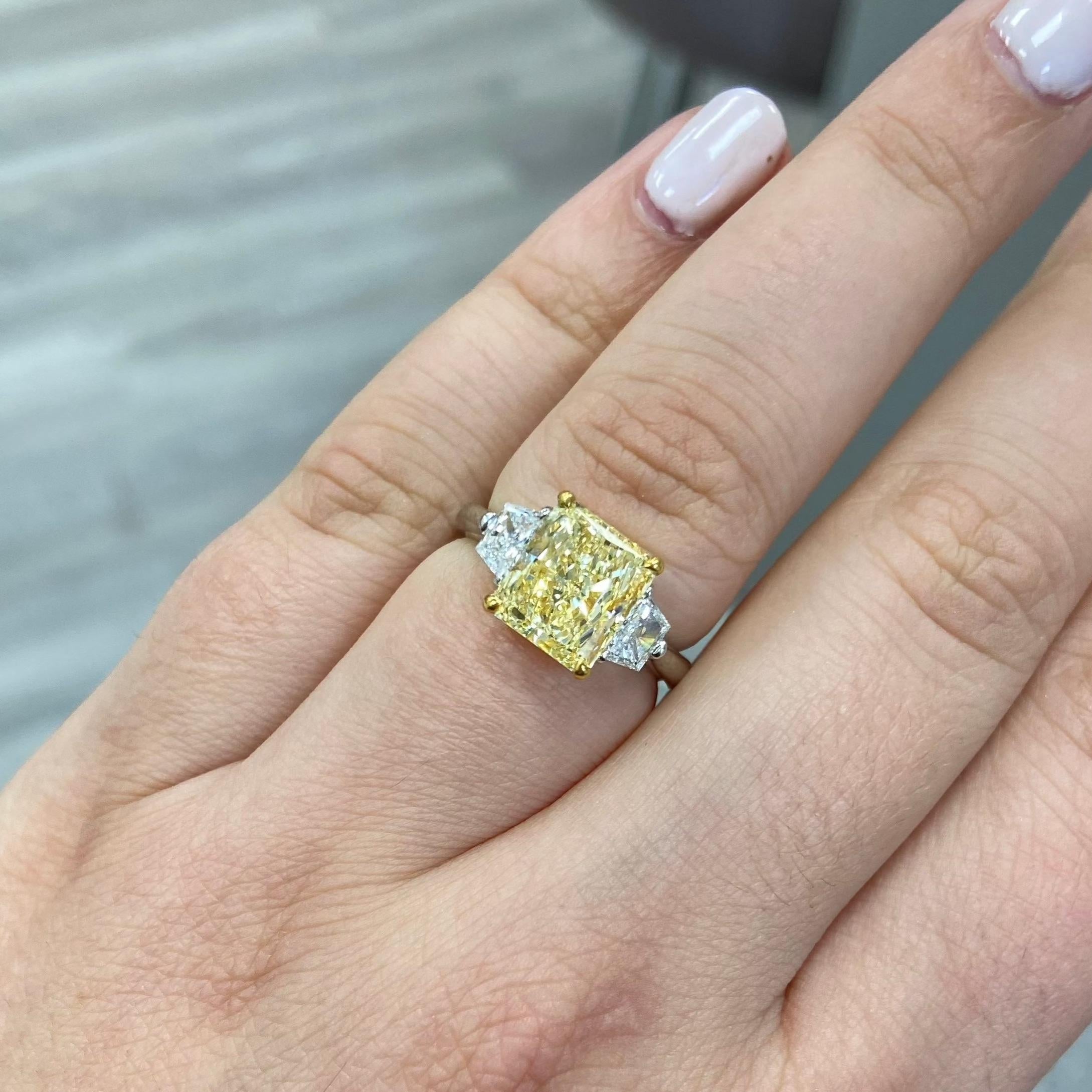 Classic and beautiful three stone ring with a 3ct Fancy Yellow elongated Radiant cut set in Platinum and 18kt 

Yellow Gold with 0.50ct total weight colorless trapezoids 

Making Extraordinary Attainable with Rare Colors


