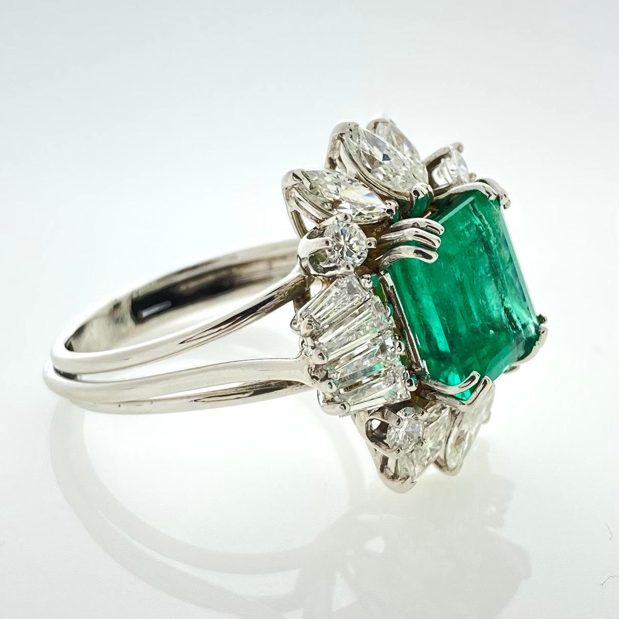 Experience the epitome of elegance with this exquisite ring featuring a stunning 3-carat green emerald as its centerpiece. Surrounded by a halo of 18 dazzling white diamonds with a total weight of 2.30 carats, this masterpiece radiates brilliance