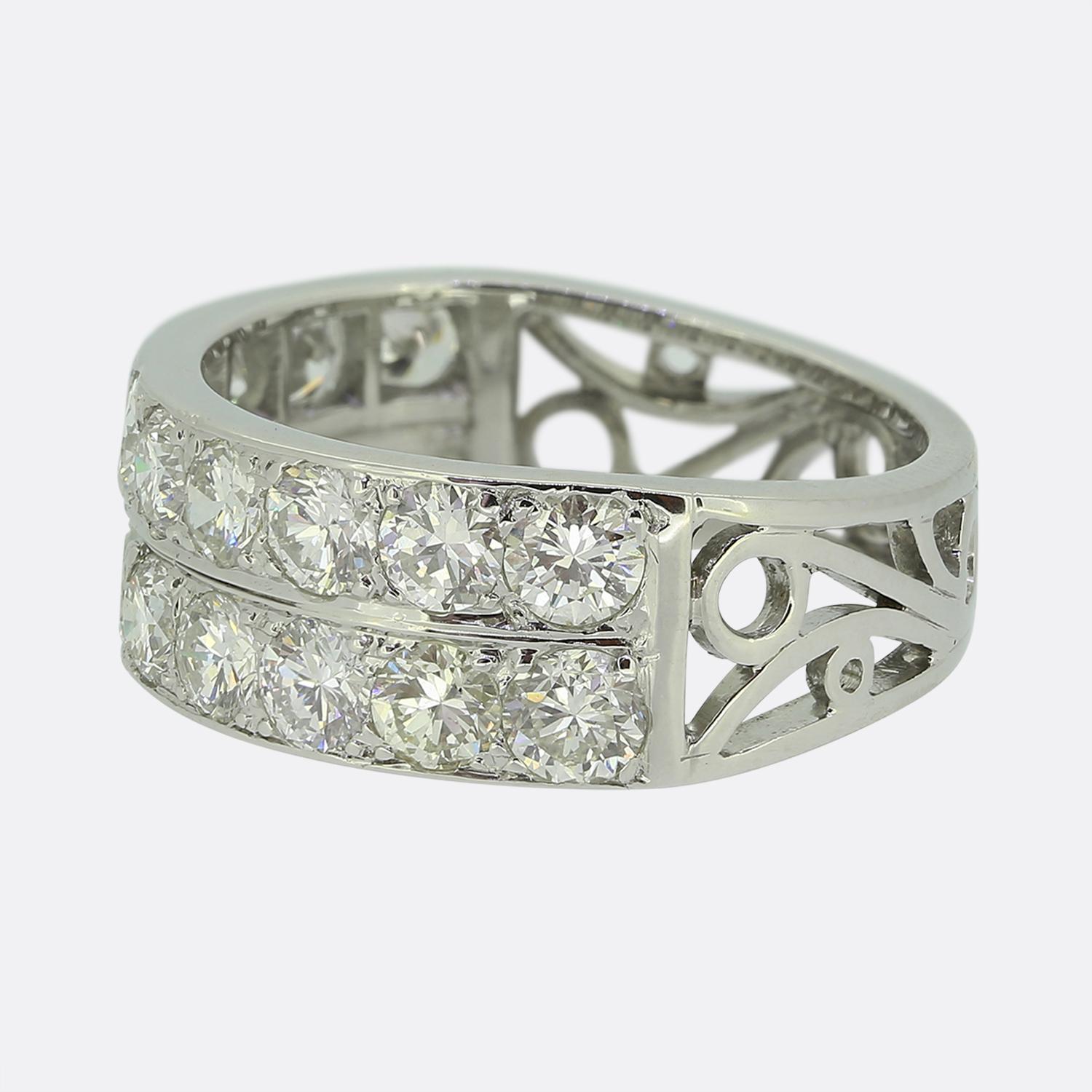 Nous avons ici une charmante bague à deux rangs de diamants. Réalisée en or blanc 18 carats, cette pièce vintage abrite 20 diamants ronds facettés de taille ancienne, d'un blanc éclatant, tous sertis individuellement sur deux rangées. Le reste de