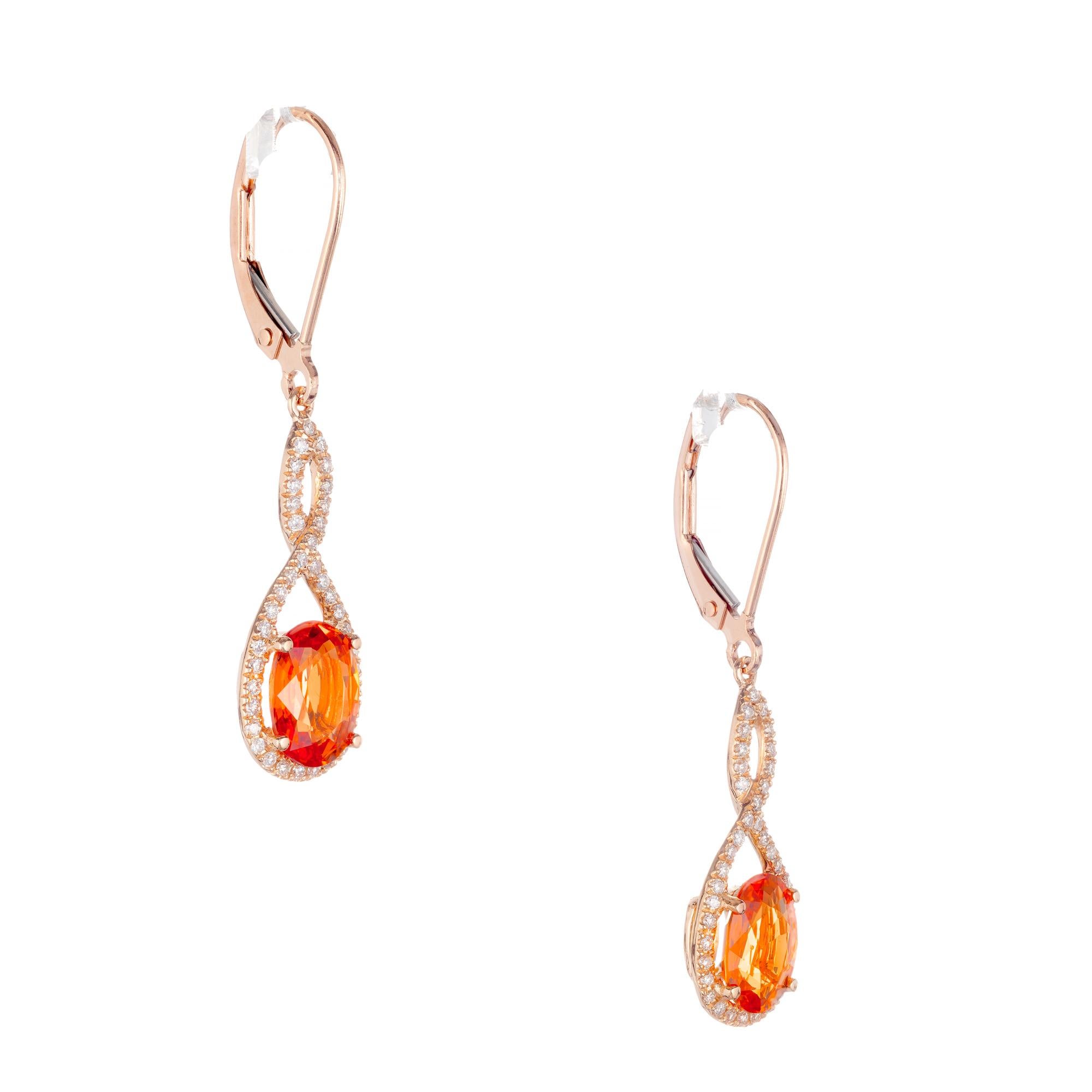 Bright oval orange Spessartite Garnet diamond dangle earrings. Two oval spessartite center stones with a figure 8 halo of round full cut diamonds. 

2 oval Spessartite orange Garnet, approx. total weight 3.00ct, 8.12 x 5.95 x 3.25mm
78 round full