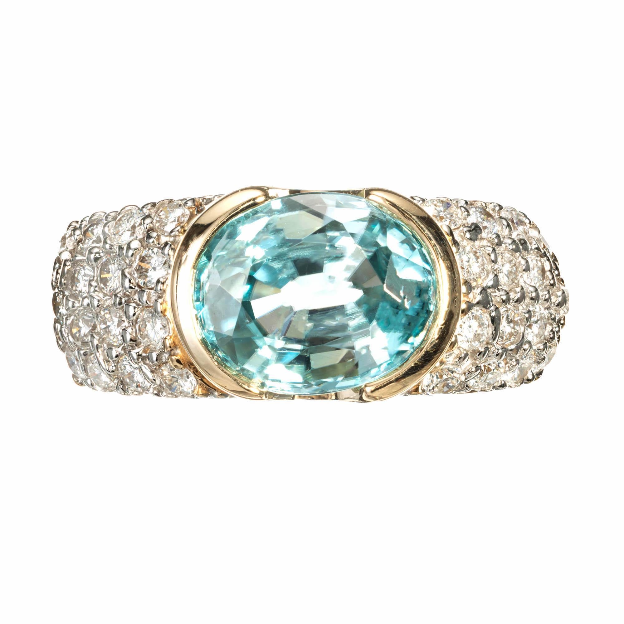  3.00ct Oval blue Zircon Diamond 14k yellow gold ring. Oval Zircon bezel set horizontally in a 14k yellow gold ring with round pave set accent diamonds set in white gold on each side of the setting.

1 oval blue Zircon, approx. total weight 3.00cts,