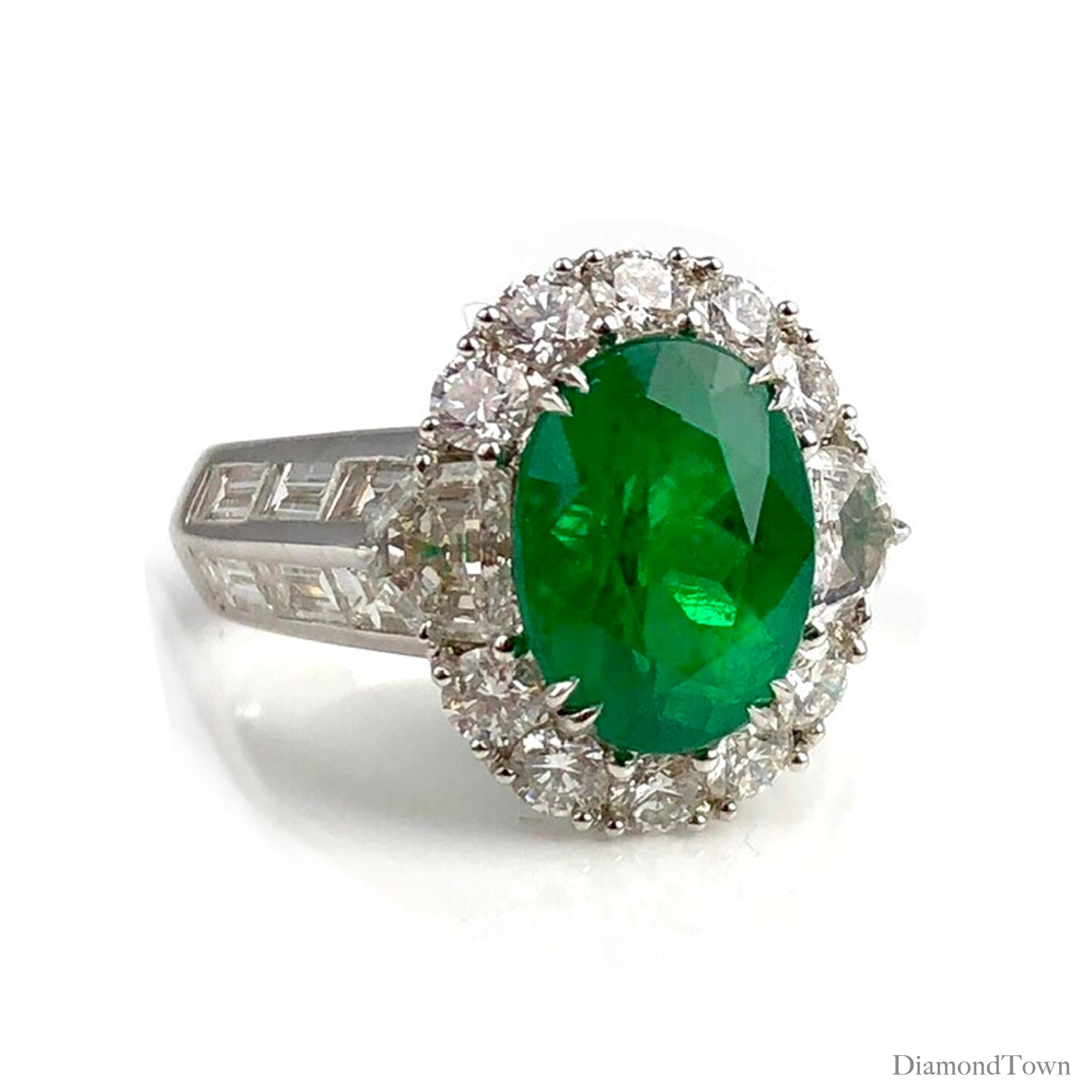 (DiamondTown) Dieser Ring funkelt mit einem kolumbianischen Smaragd von 3,00 Karat in der Mitte, umgeben von einem Halo aus weißen Diamanten und weiteren Diamanten, die sich über den seitlichen Schaft erstrecken. (Gesamtgewicht der Diamanten 2,50