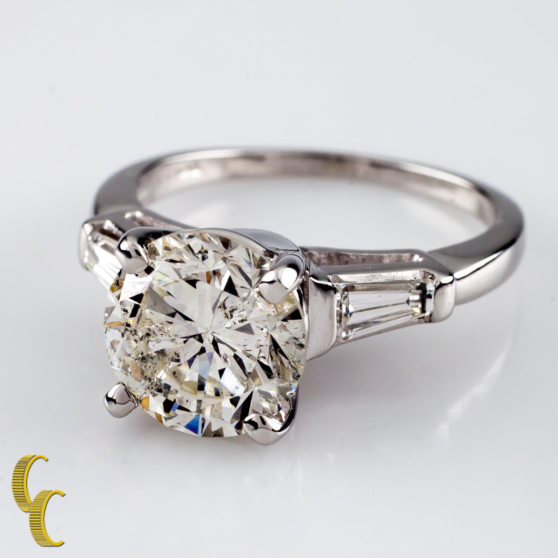 18 karat white gold setting 
Ring size = 6.25
Diamond Center Stone Specs:
Diamond Carat weight: 3.00 carats
Diamond Color Grade: I
Diamond Clarity Grade: I1
Total Mass: 6.5 grams