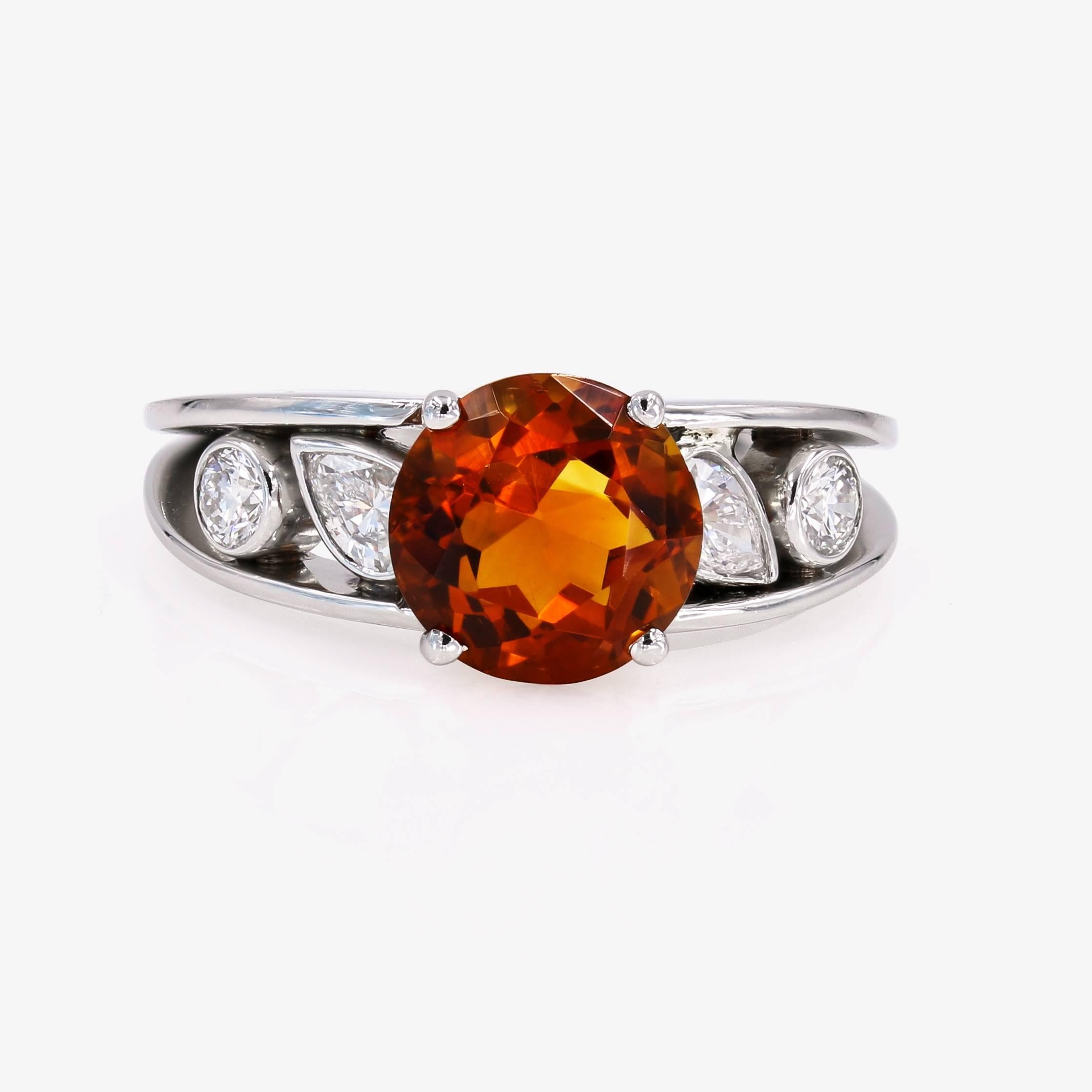 This vibrant ring contains a 3.00cts. round center citrine of orange-brownish color. There are 2 pear shape diamonds on the sides=.39ct. t.w. and 2 ideal cut round diamonds=.24ct. t.w. The ring is set in platinum.
(diamonds are G in color and VS
