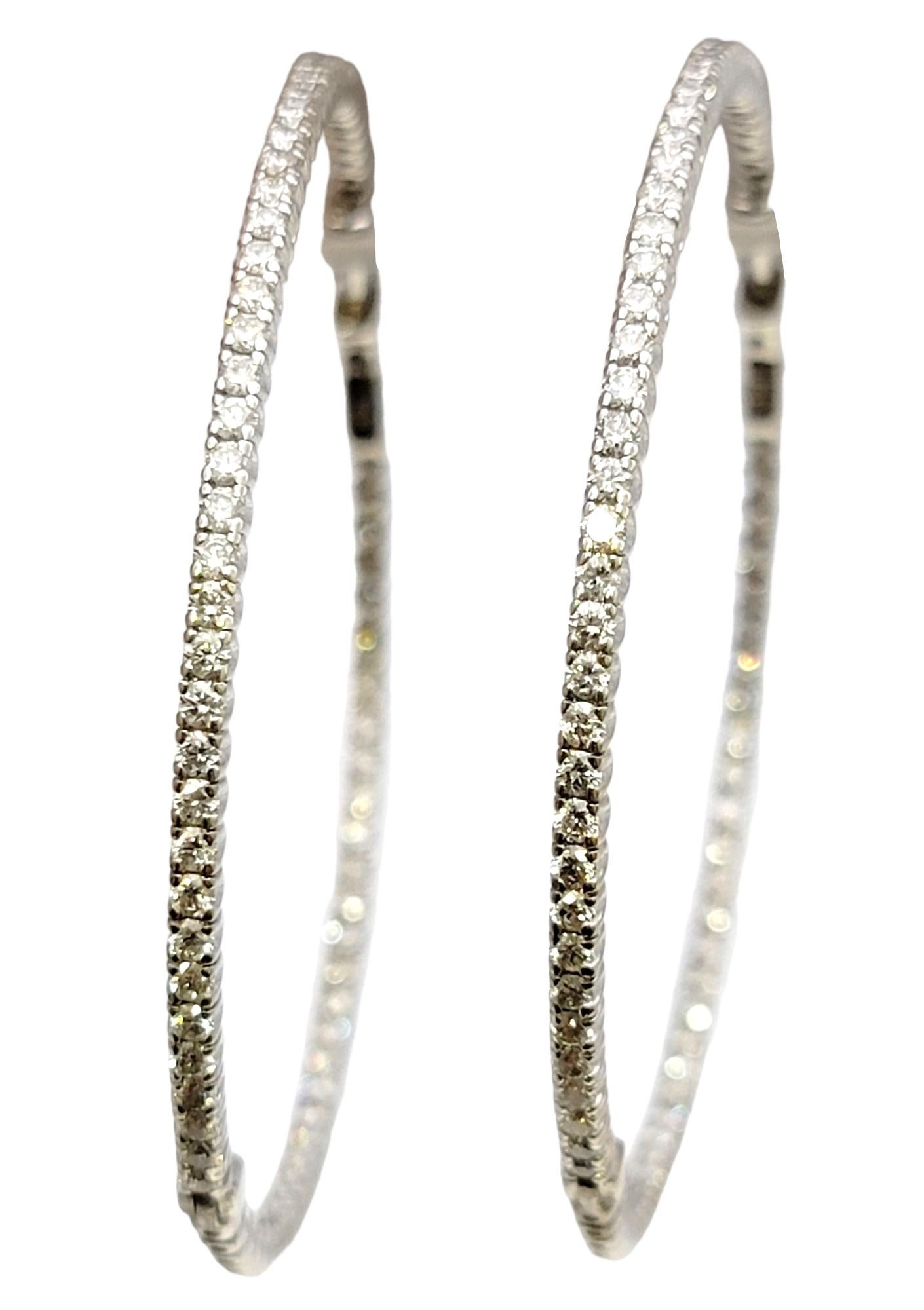 Absolutely gorgeous oversize pave diamond hoop earrings. The stunning pair are arranged in a delicate inside/outside setting, so the diamonds are positioned to catch the light from all angles. Hanging just over 2 inches long, these chic earrings are