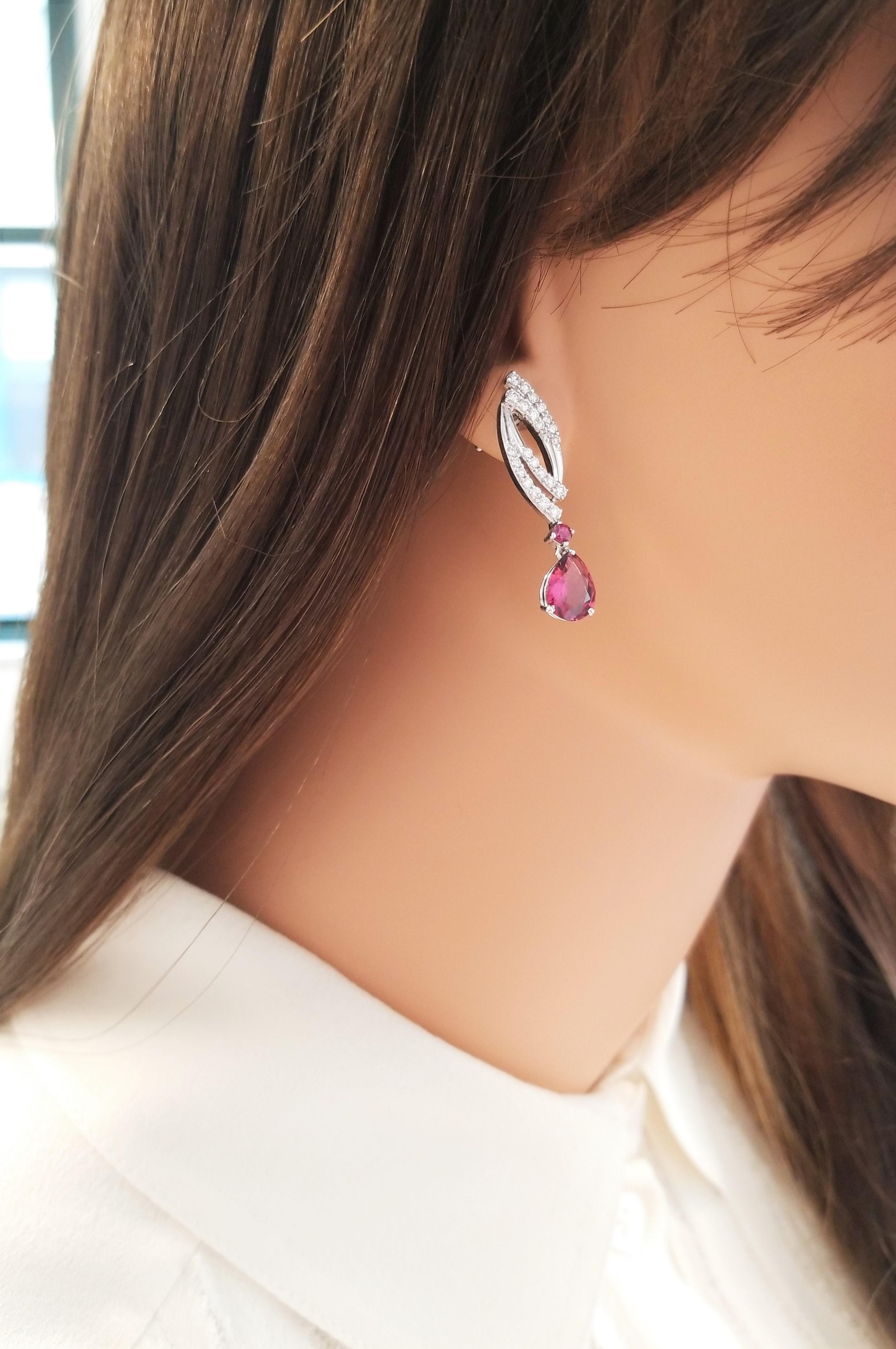These dynamic dynasty style earrings feature a sweeping design that showcases 4 vibrant raspberry rubellite tourmalines, prong set, totaling 3.00 carats. The gem source is Brazil; their color hue is vivid purplish-red; clarity, luster, and