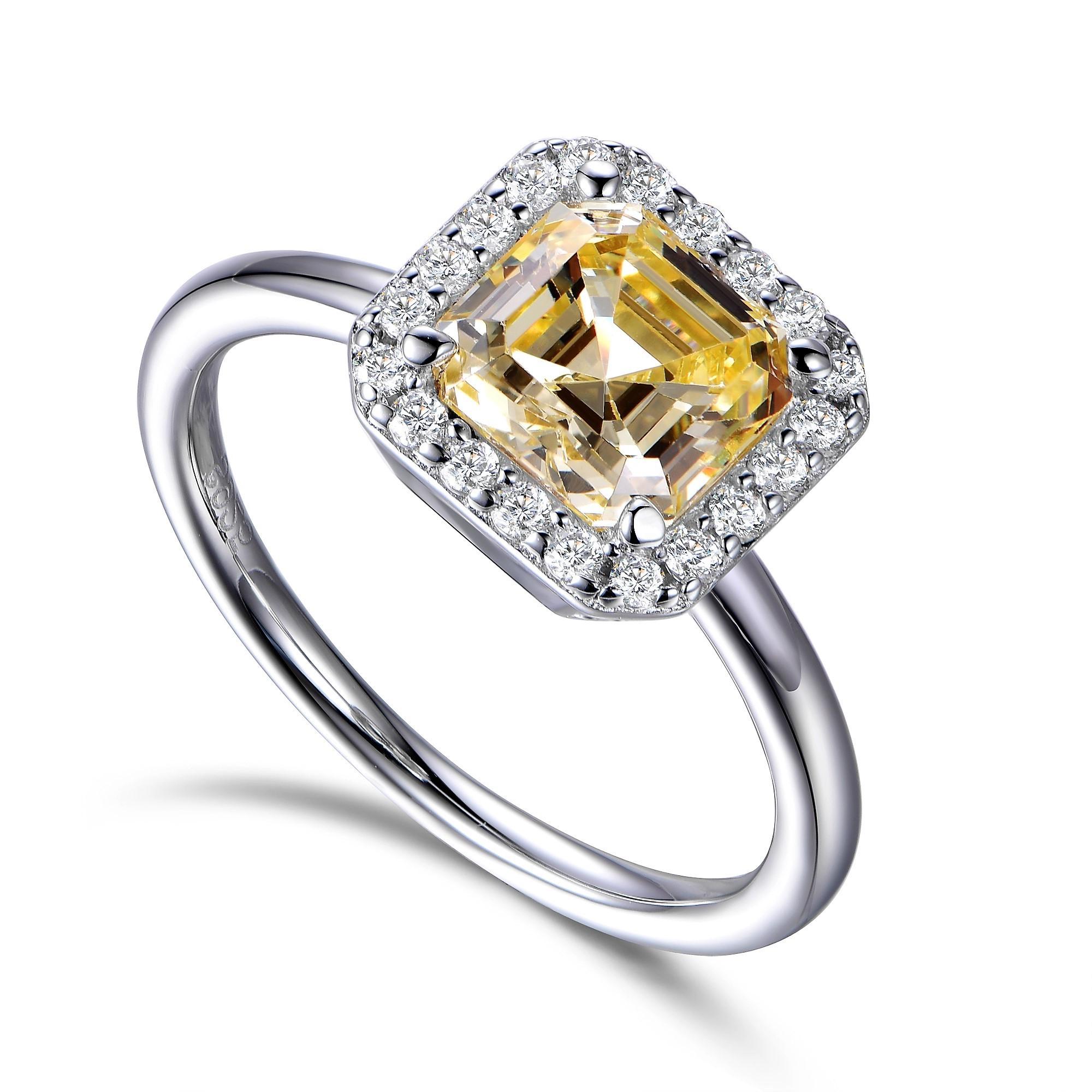 Golden honey tones emanate from this stylish 3.00ct yellow asscher cut cubic zirconia surrounded by a halo of 20 smaller round brilliant cut cubic zirconia. 

Composed of 925 sterling silver with a high gloss white rhodium finish. 

Matching Yellow