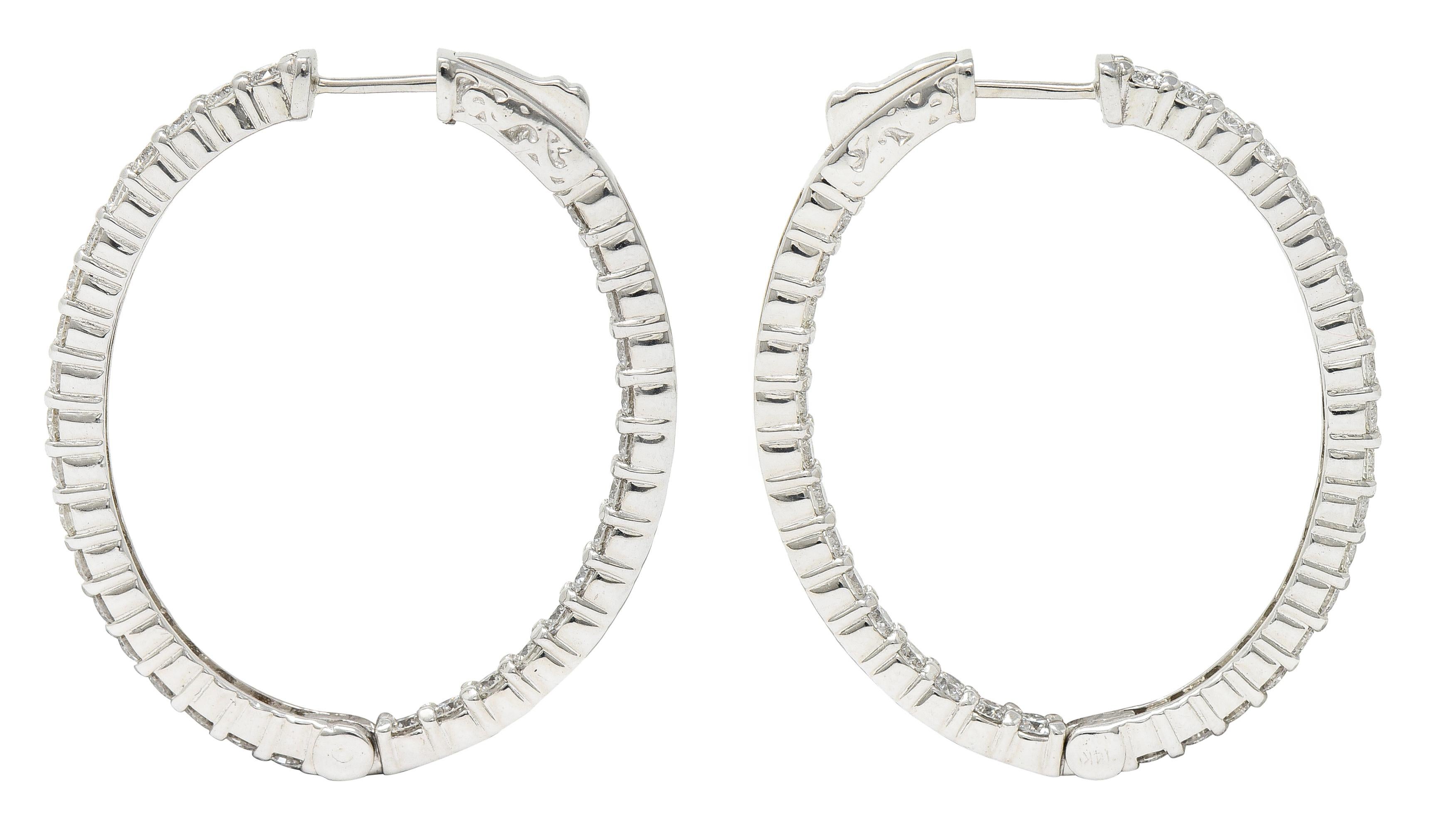 Inside/outside style oval shaped huggie hoop earrings

With round brilliant cut diamonds in shared prongs

Weighing in total approximately 3.00 carats - G/H color with overall VS clarity

Opens on a hinge via presser revealing posts

Inscribed with