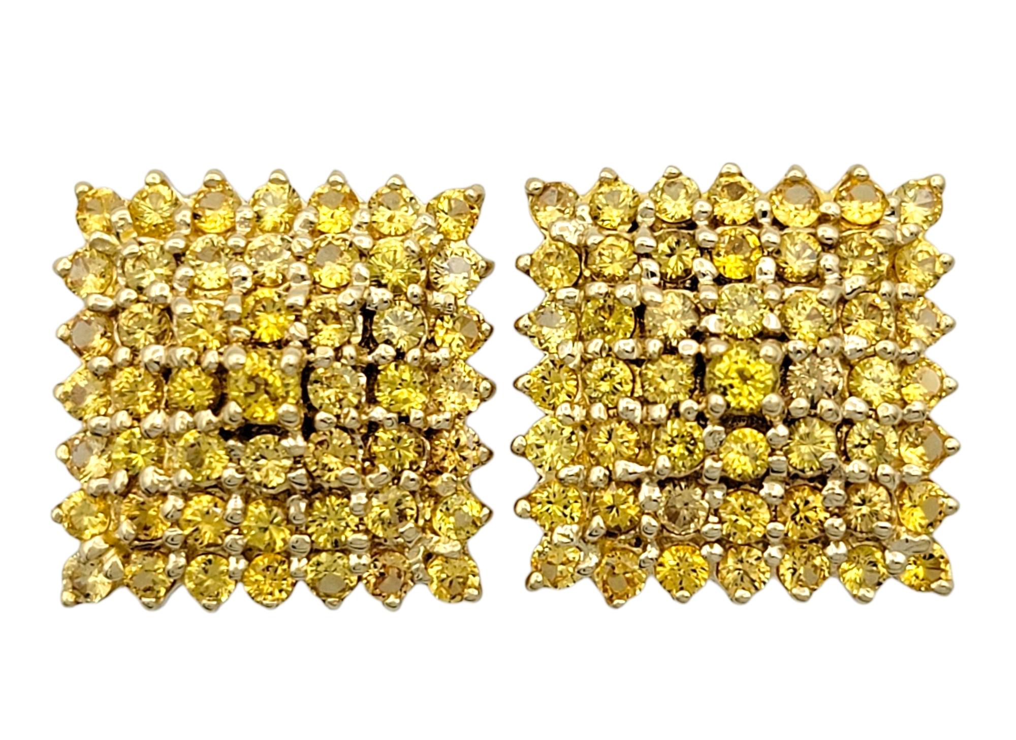 Radieuses et vibrantes, ces remarquables boucles d'oreilles en saphir sont réalisées en or jaune 18 carats et présentent un éventail de saphirs jaunes de taille ronde disposés dans une silhouette carrée spectaculaire. La teinte vive et le cadre