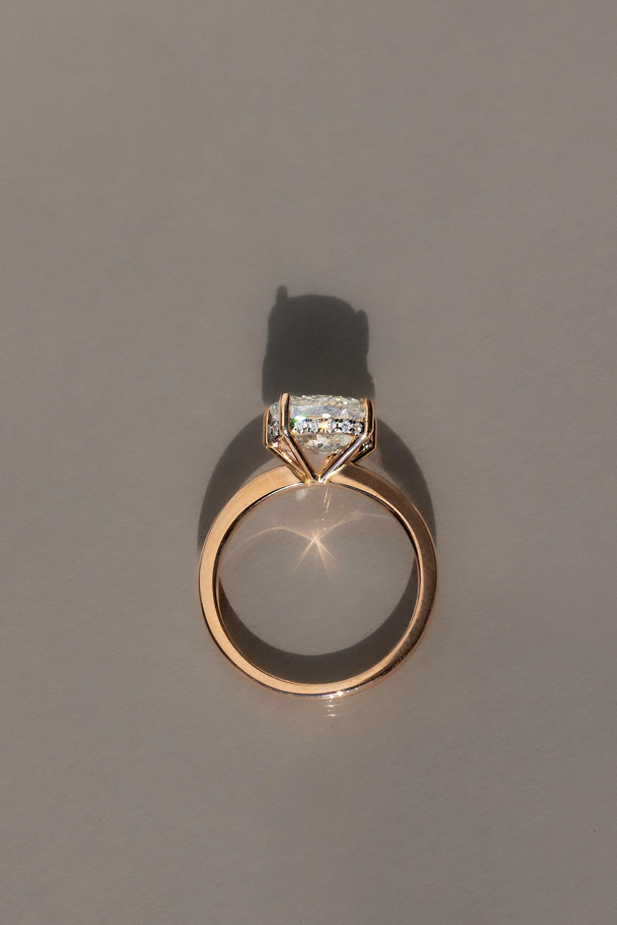 This 3.00 ct cushion-cut diamond, set in 18ct rose gold, showcases a perfect blend of modern elegance and timeless beauty. The cushion cut’s soft edges and remarkable sparkle are accentuated by five asymmetrical prongs, creating a contemporary and