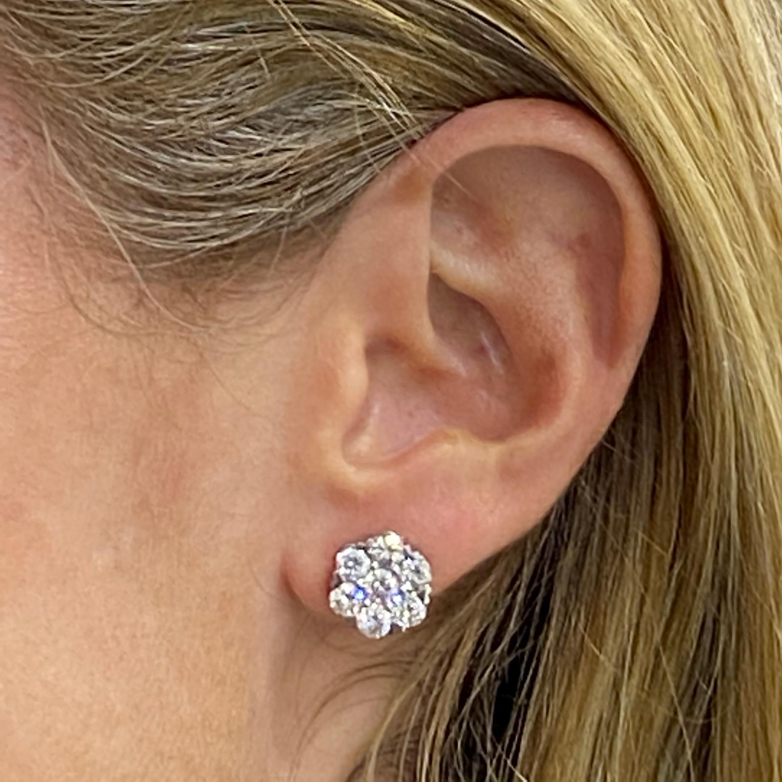 Diamond flourette stud earrings fashioned in 18 karat white gold. The studs feature 14 round brilliant cut diamonds weighing approximately 3.00 carat total weight. The diamonds are graded G color and VS-SI1 clarity. Measure: 11.5 mm in diameter. 