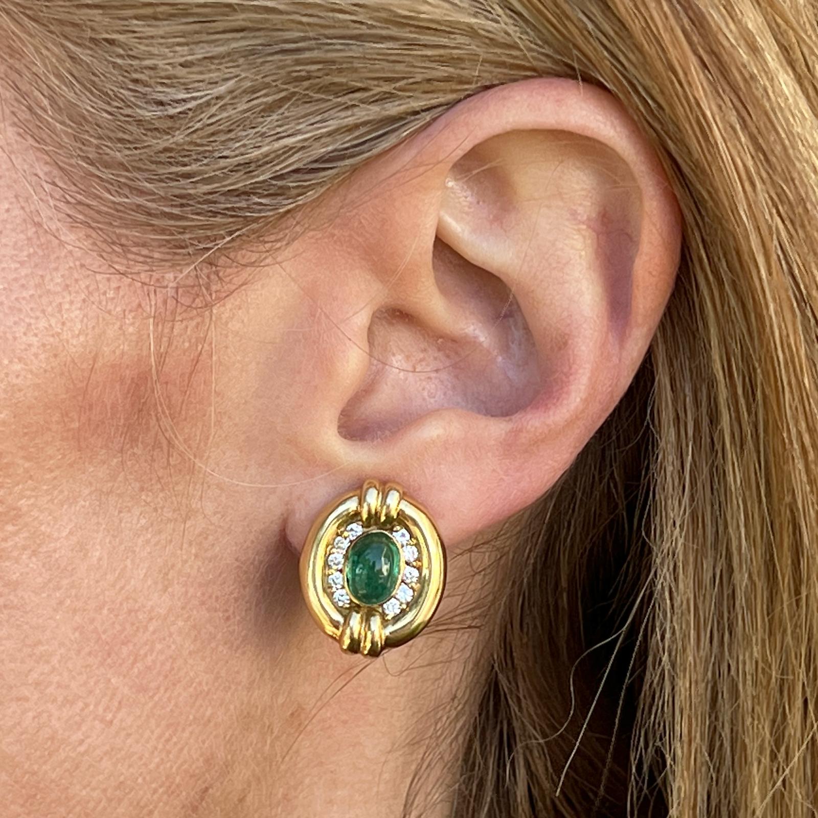 Emerald and diamond earrings crafted in 18 karat yellow gold. The earrings feature 2 cabochon natural emerald gemstones weighing approximately 3.00 CTW and 20 round brilliant cut diamonds weighing .50 CTW. The diamonds are graded G-H color and VS