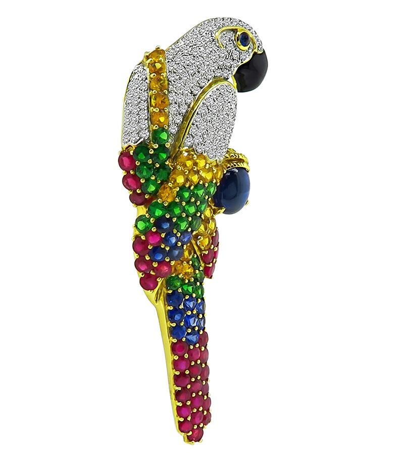 This is a fabulous 18k yellow and white gold cockatoo pin. The pin is set with sparkling round cut diamonds that weigh approximately 3.00ct. The color of these diamonds is H with VS clarity. The diamonds are accentuated by cabochon star sapphire,