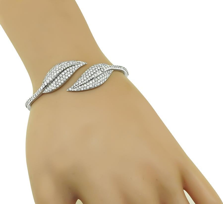 This is a stunning 18k white gold bangle. The bangle is set with sparkling round cut diamonds that weigh approximately 3.00ct. The color of these diamonds is G with VS clarity. The bangle measures 20mm in width at the widest base and weighs 18.3