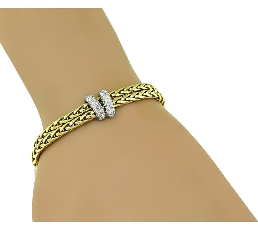 This is an elegant 18k yellow and white gold bracelet. The bracelet is set with sparkling round cut diamonds that weigh approximately 3.00ct. The color of these diamonds is F with VS clarity. The bracelet measures 11mm in width at the widest base