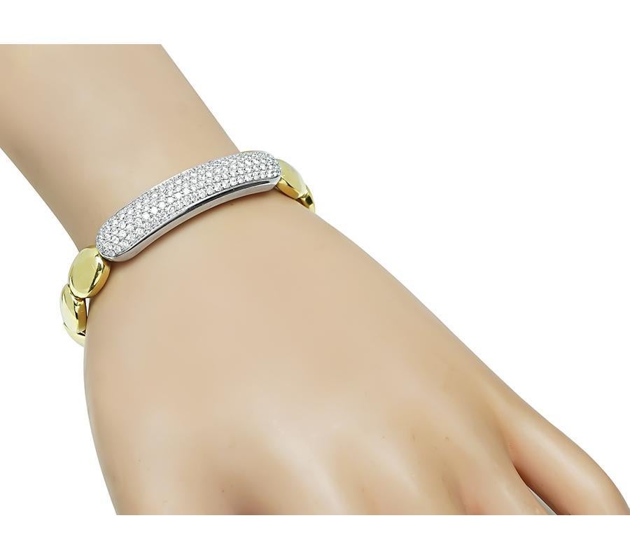 This is an elegant 18k yellow and white gold flexible bangle. The bangle is set with sparkling round cut diamonds that weigh approximately 3.00ct. The color of the diamonds is F with VS clarity. The bangle measures 10mm in width and will fit