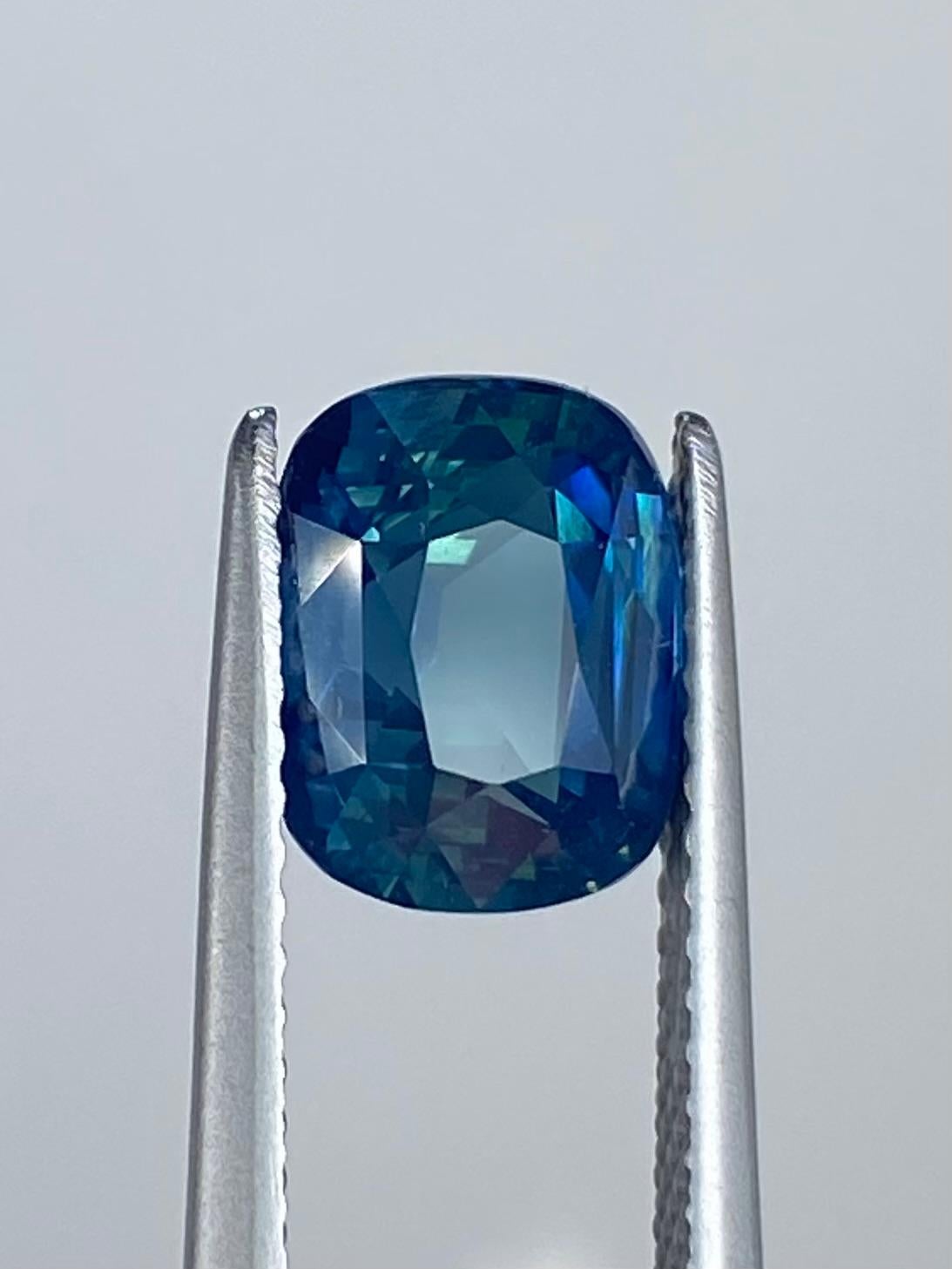 Le marchand de saphirs présente ce superbe saphir bleu sarcelle opalescent naturel. Cette pierre précieuse d'un poids impressionnant de 3,00 carats est présentée dans une forme coussin intemporelle qui rayonne d'élégance. Avec sa clarté VVS, il est