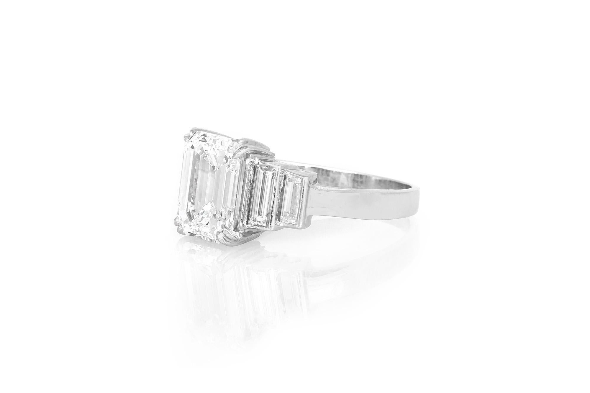 Fein in Handarbeit in Platin mit einem GIA-zertifizierten Smaragdschliff Diamant mit einem Gewicht von 3,01 Karat, G Farbe, VS1 Klarheit, GIA #11194917.
Der Ring hat 4 Diamanten im Baguetteschliff mit einem Gesamtgewicht von etwa 1,30 Karat.
Größe 7