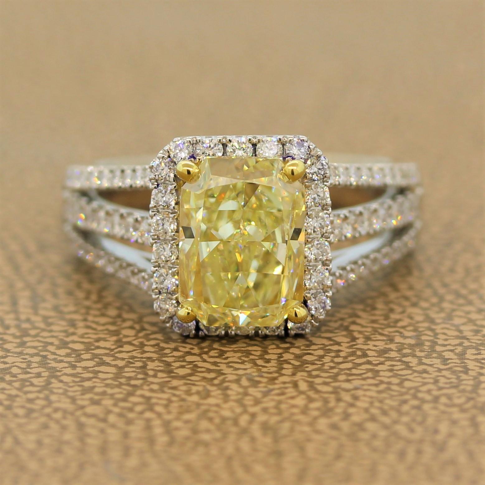 A spectacular ring featuring a 3.01 carat fancy yellow diamond in an 18K yellow gold setting. The radiant cut diamond is haloed by 0.76 carats of diamonds that go along the double split shank of the 18K white gold ring. 

Ring Size 6.50 (Sizable)

