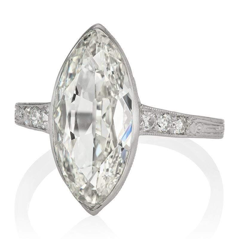 This ring is an authentic vintage engagement ring from the Art Deco Era. The ring centers a GIA certified 3.01-carat Marquise cut diamond of J color, VS1 clarity. The stone is bezel-set in a platinum setting with three diamonds set into each