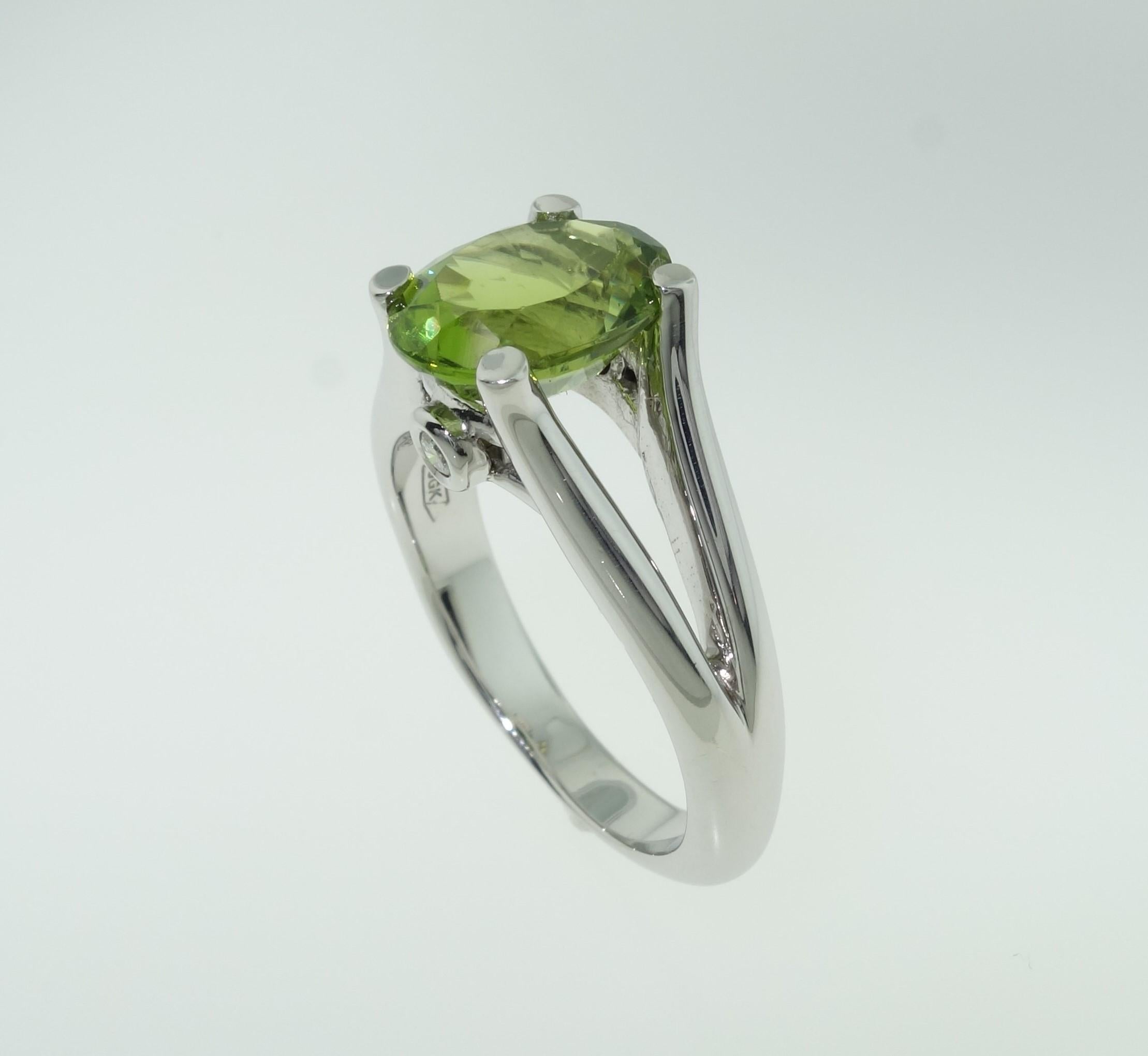 Beautiful ring featuring a 3.01 Carat Peridot in center enhanced on either side with Diamonds; approx. 0.06 total carat weight; Sterling Silver Tarnish-resistant Rhodium mounting. Size 8, we offer ring re-sizing; Classic and Stylish…illuminating