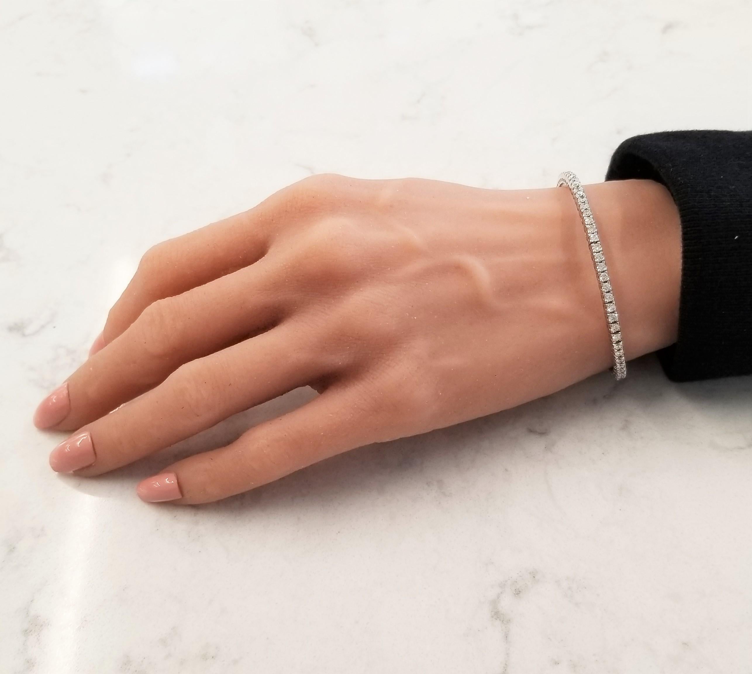 This lavish stretchy bangle bracelet features a sparkling row of round brilliant cut diamonds expertly prong set in modern square-shaped links. Each diamond sits next to each other, set from end to end eternity style displaying maximum fire and
