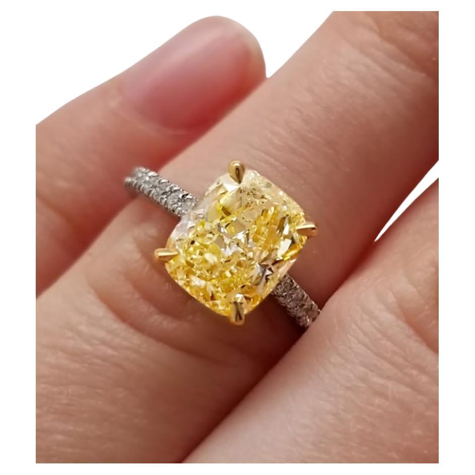 GIA certified Natural 3.01 ct Cushion Cut Fancy Yellow SI1 18K White Gold band embellished with white melee diamonds. 18k gold and platinum band featuring a 3.01 ct GIA certified cushion cut center stone, natural fancy yellow diamond, emphasized by