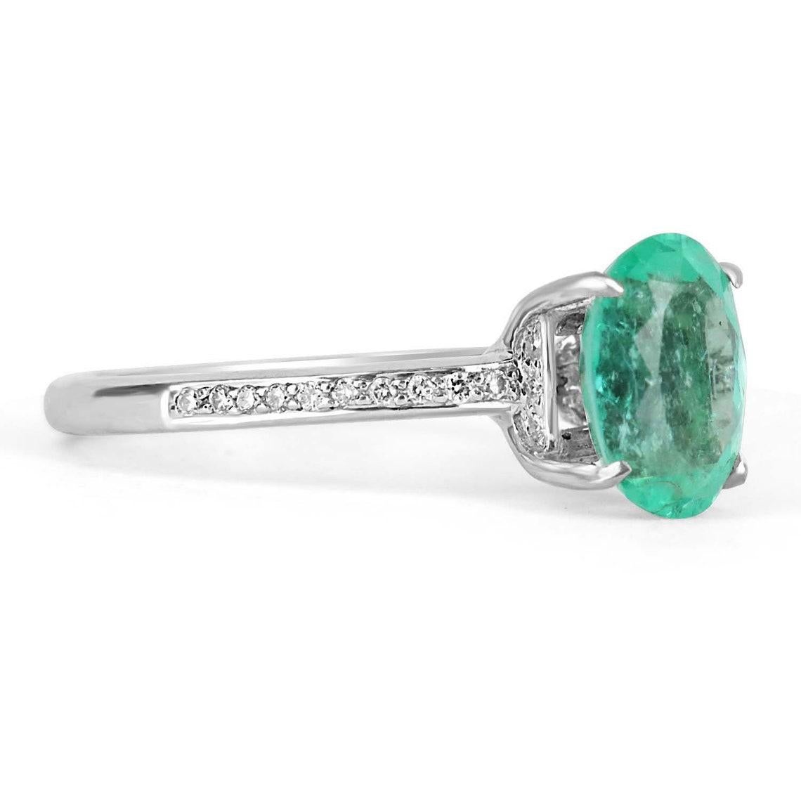 Elegantly displayed is a natural, emerald-cut Colombian emerald and diamond accent engagement ring. The center gem is a good quality, oval cut, emerald filled with life and brilliance! Among the emerald impressive qualities are its vibrant color and