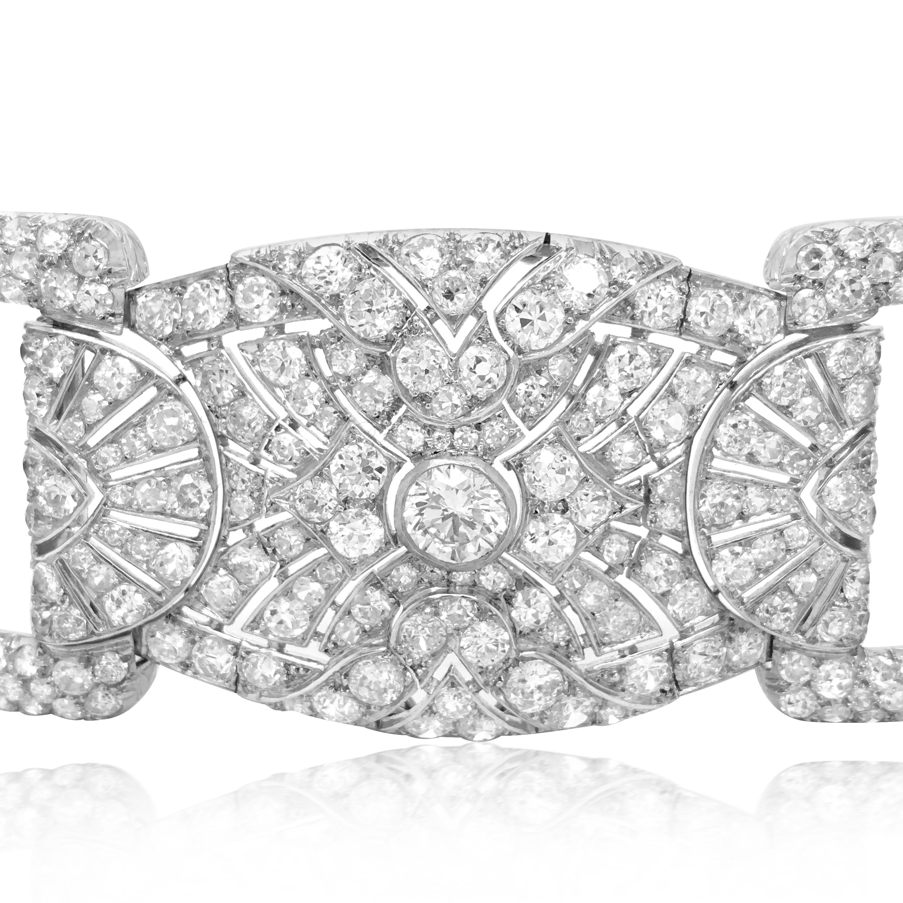 This breathtaking bracelet is finely crafted in solid platinum, weighing 97 grams and measuring 18cm (7'') long. It is adorned with three large round-cut diamonds in the center of each diamonds plaque with other various cut diamonds, weighing