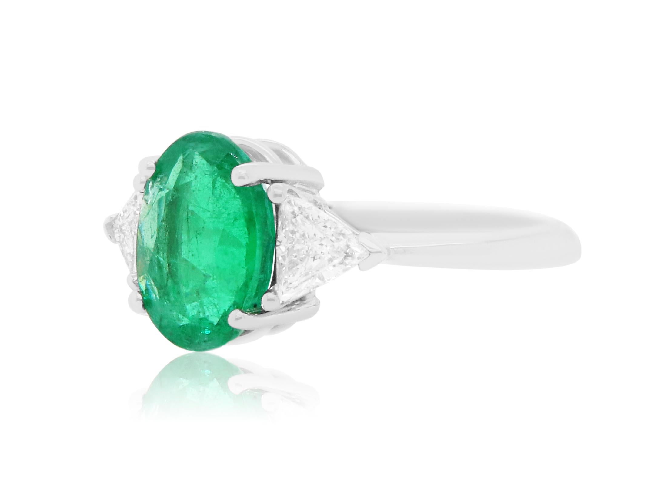 Material: 18k White Gold 
Center Stone Details: 1 Oval Emerald at 3.02 Carats - Measuring 8.2 x 10.9 mm
Diamond Details: 2 Brilliant Trillion Shaped White Diamonds at 0.58 Carats - Clarity: SI / Color: H-I
Alberto offers complimentary sizing on all