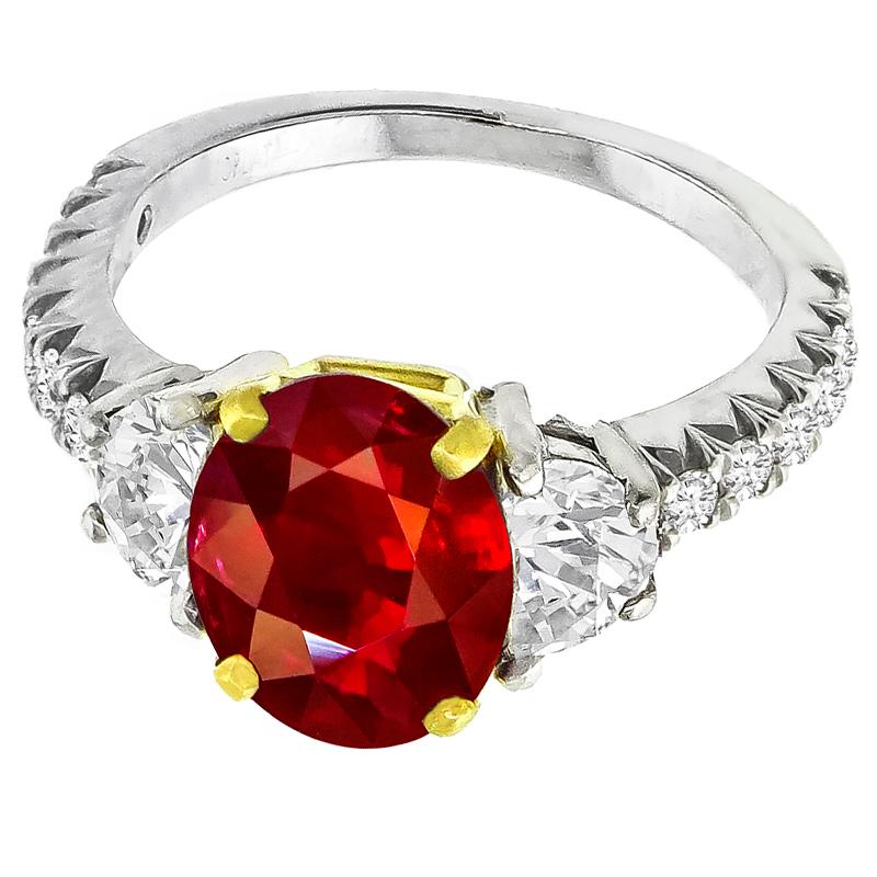 Made of platinum and 18k yellow gold, this ring centers a lovely oval cut ruby that weighs 3.02ct. The center stone is accentuated by sparkling half moon and round cut diamonds that weigh approximately 0.70ct and 0.80ct respectively. The color of