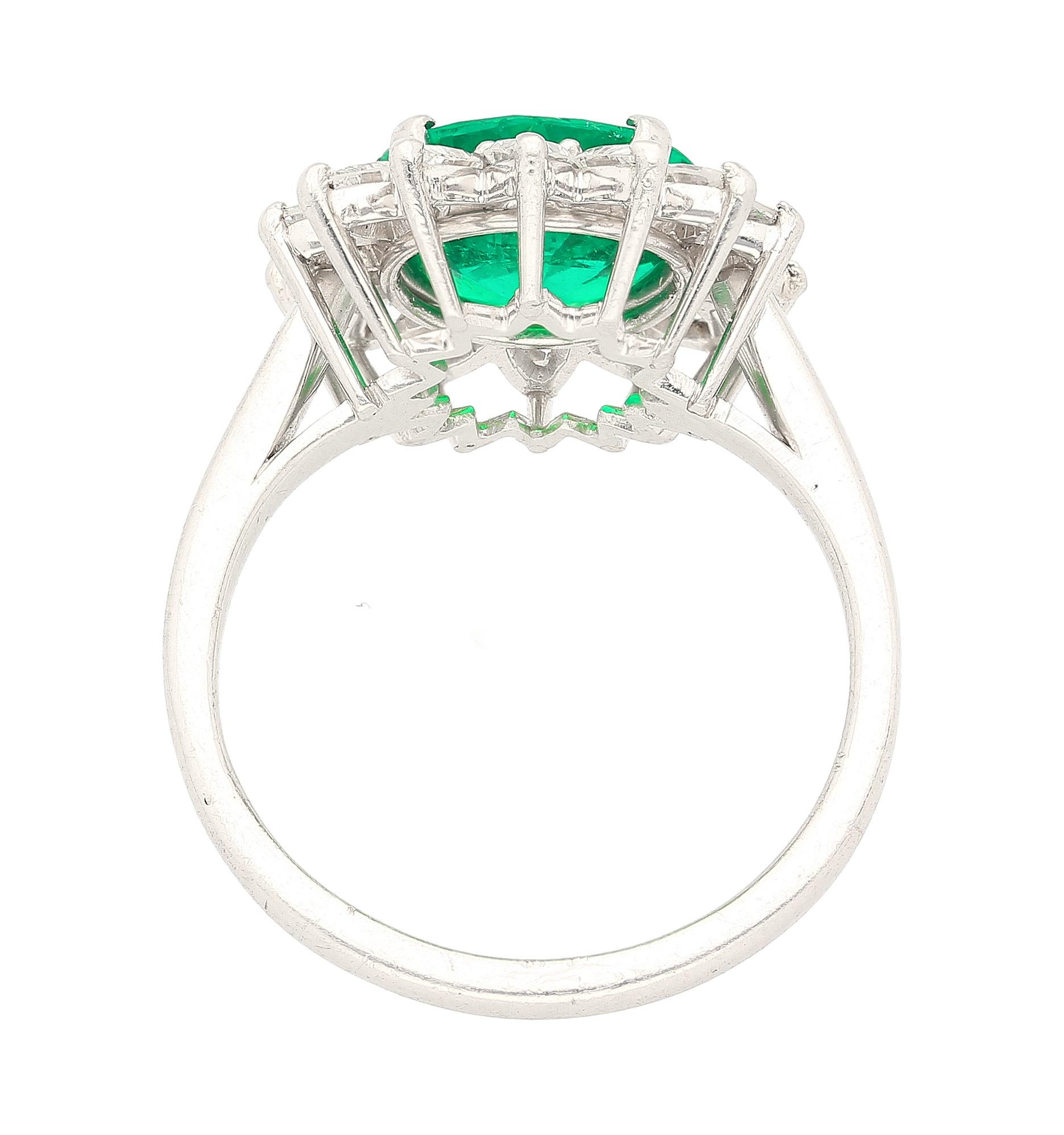 Bague de fiançailles en platine certifié GRS, centrée sur une émeraude naturelle de 3,02 carats et un halo de diamants naturels de 1 carat au total. L'émeraude se caractérise par une couleur verte vive, une origine colombienne et un traitement à