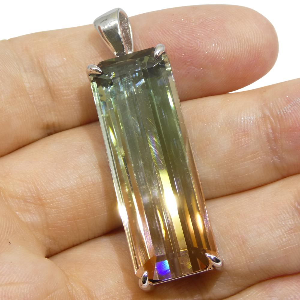Elevate your collection with a truly one-of-a-kind statement piece. This extraordinary pendant showcases a 30.21-carat emerald-cut bi-colour tourmaline, masterfully set in luxurious 18k white gold. With a captivating blend of pink and bluish green