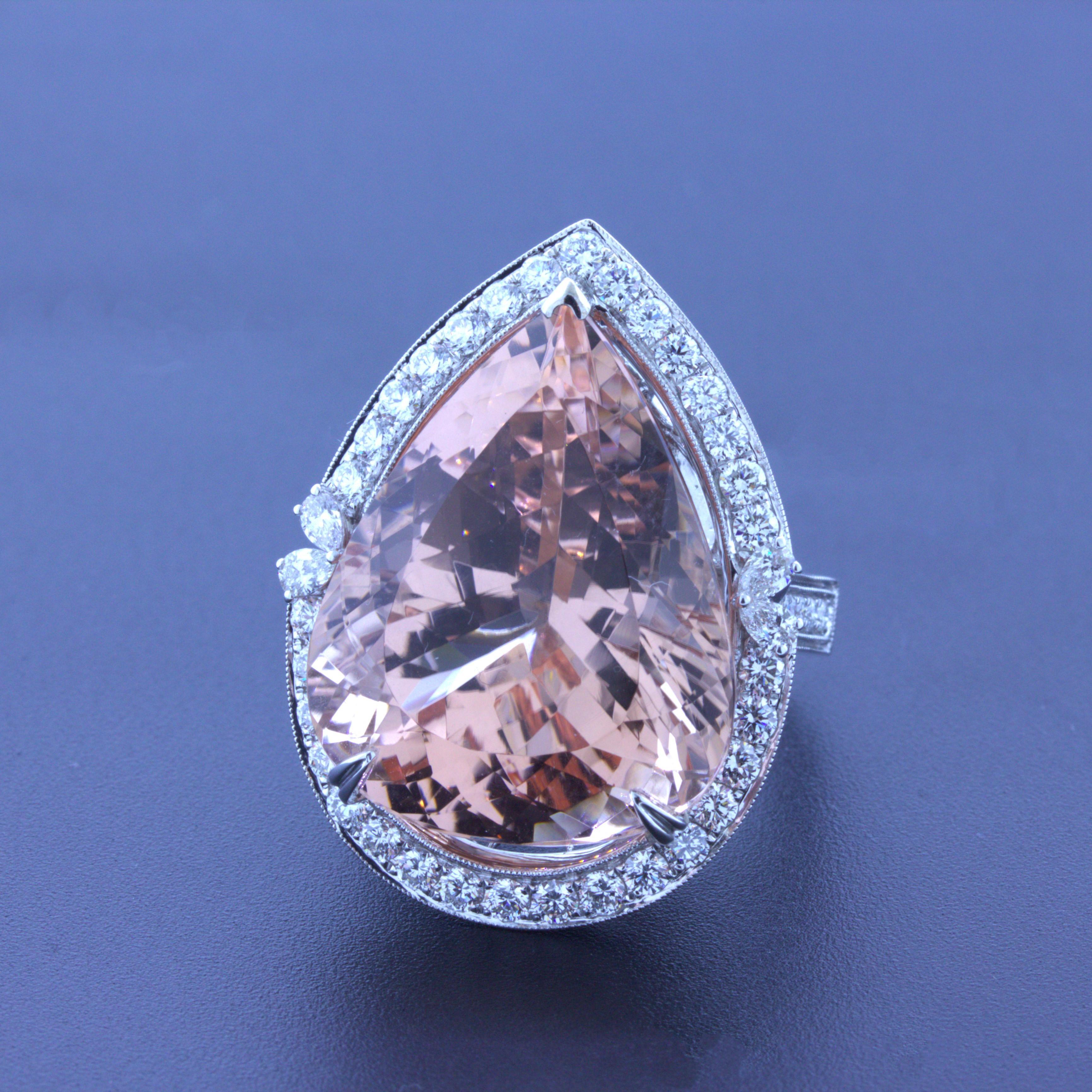 A chic and elegant cocktail ring featuring a large 30.27 carat morganite! It has a lovely pear-shape along with a rich peach color with excellent light return due to the stones' precise cutting and polishing. It is complemented by 1.57 carats of