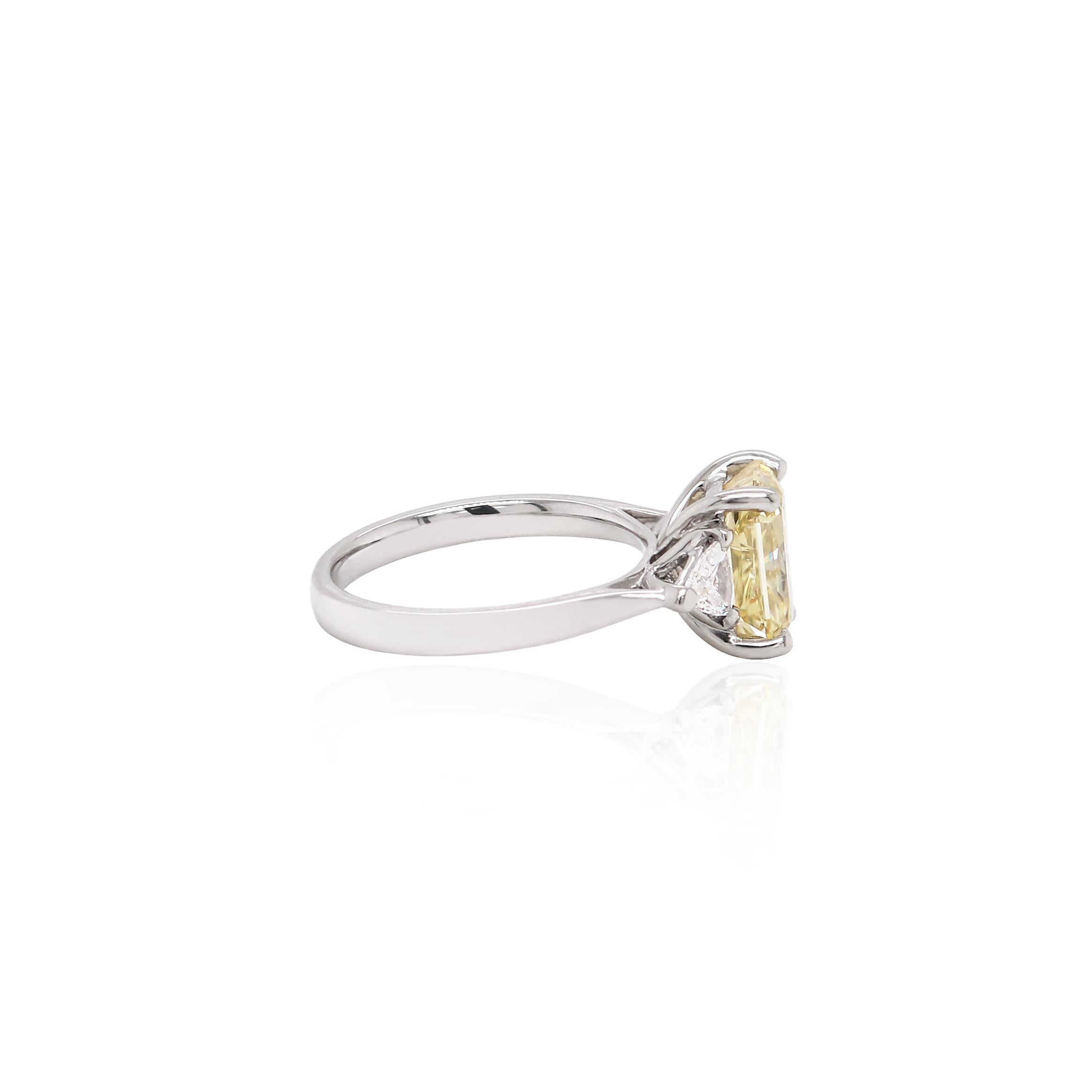 This exquisite engagement ring features a certified fancy intense brownish yellow radiant cut diamond in a four claw, open back setting. This beautiful diamond is accompanied by a trillion cut diamond on either side weighing a total of 0.35ct in
