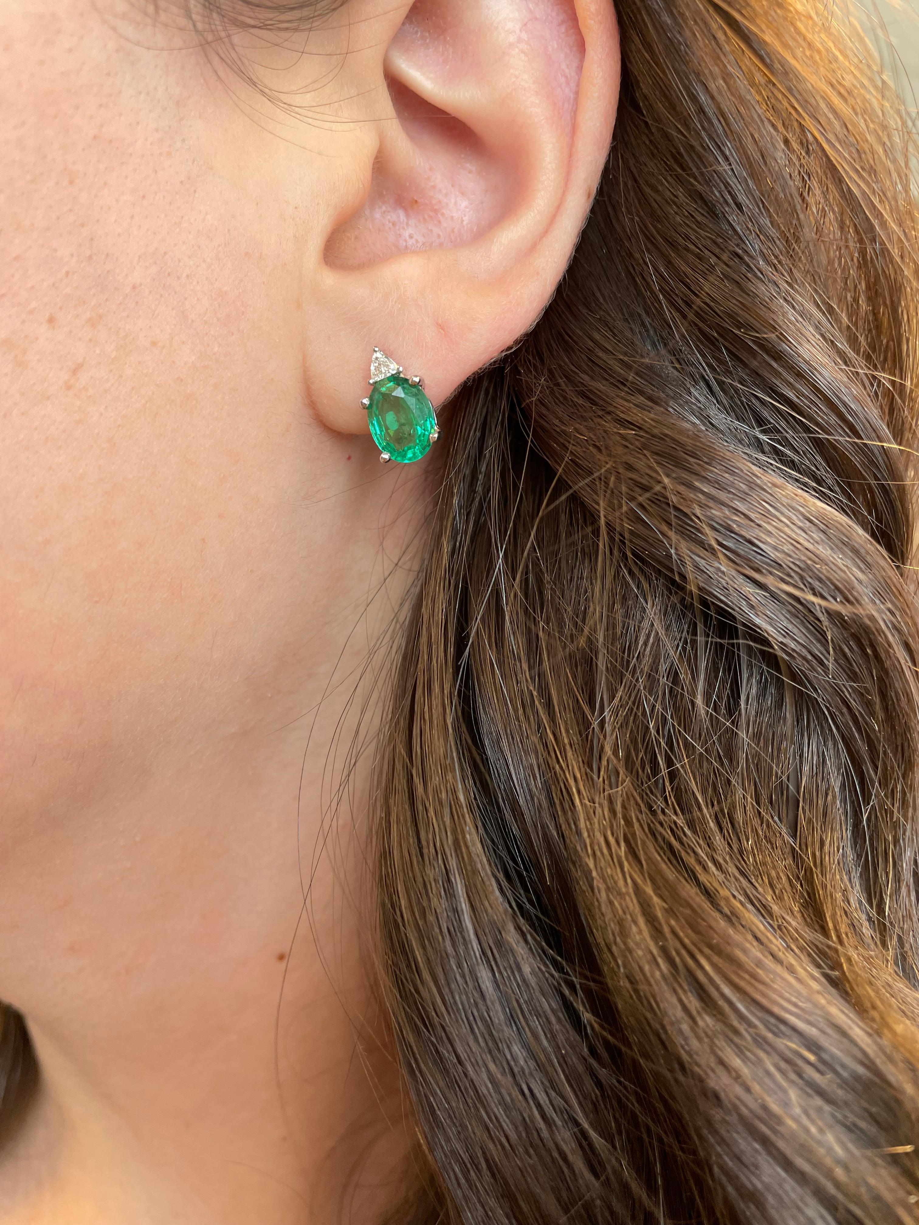 Simple yet modern emeralds with diamonds earrings.
3.15 carats total gemstone weight.
3.02 carat oval emeralds, apx F2. 0.13 carats of trilliant cut diamonds, approximately G/H color and SI clarity. 18-karat white gold.
Ask us about the matching