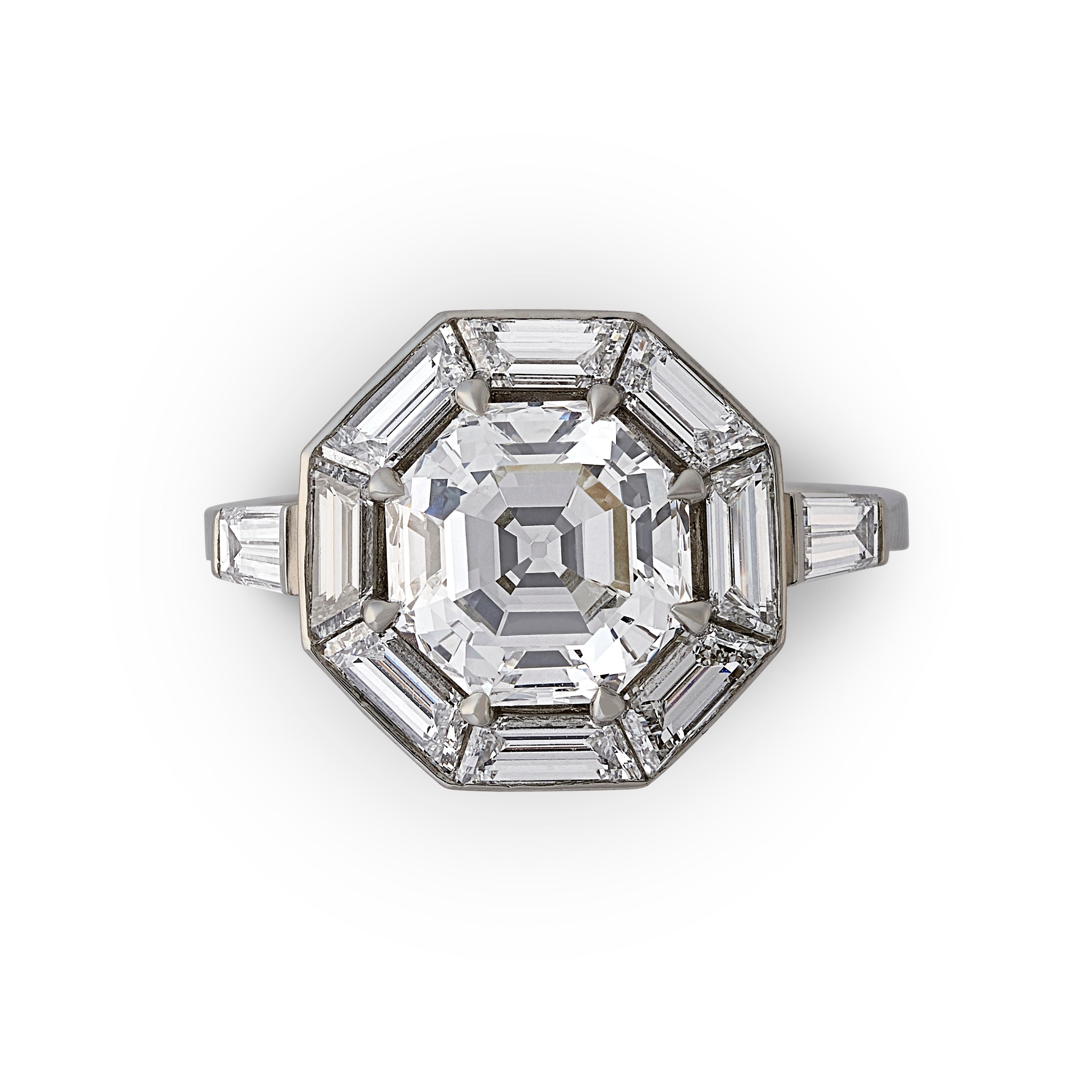 3.02ct Vintage octagonal diamond ring by Hancocks, centred on a beautiful step-cut octagonal diamond weighing 3.02cts and of F colour and VS1 clarity claw set within a calibre-cut halo of trapezoid diamonds in a channel setting between elegantly