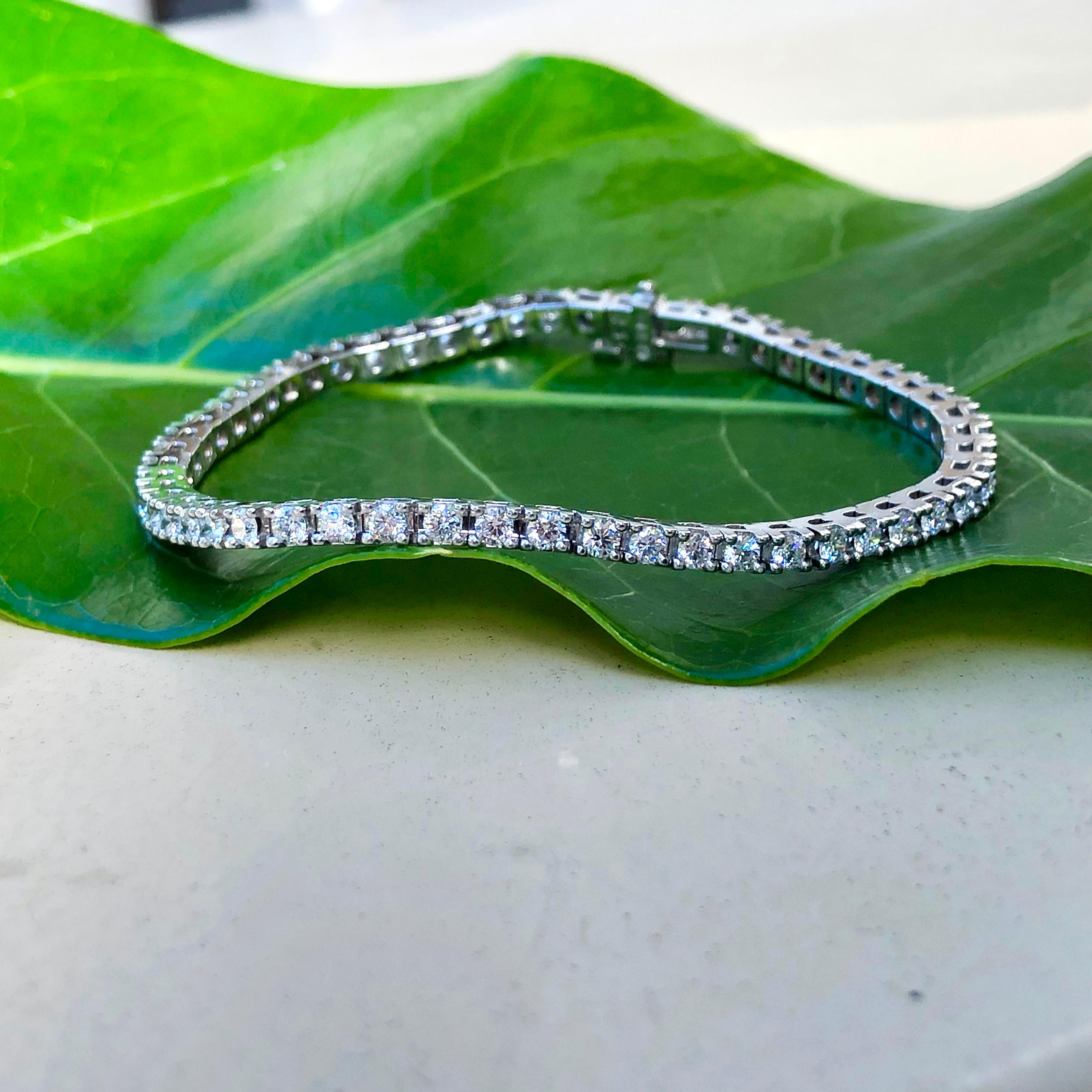 18k white gold tennis bracelet is set with fifty-five (55) Round Brilliant Cut diamonds that measure 2.5mm and weigh a total of 3.03 carats with Clarity Grade VS and Color Grade F-G. The bracelet is 7 1/16