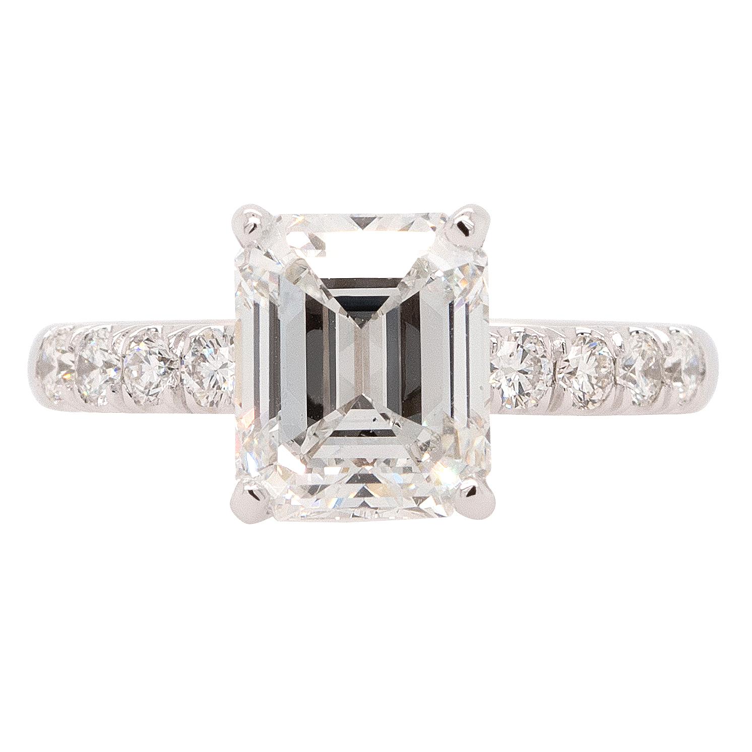 This captivating ring features a stunning 3.03ct emerald-cut GIA diamond in a 14k white gold setting. The diamond, with its impressive F color and VVS2 clarity, radiates brilliance and beauty. Complemented by a cluster of round cut natural diamonds