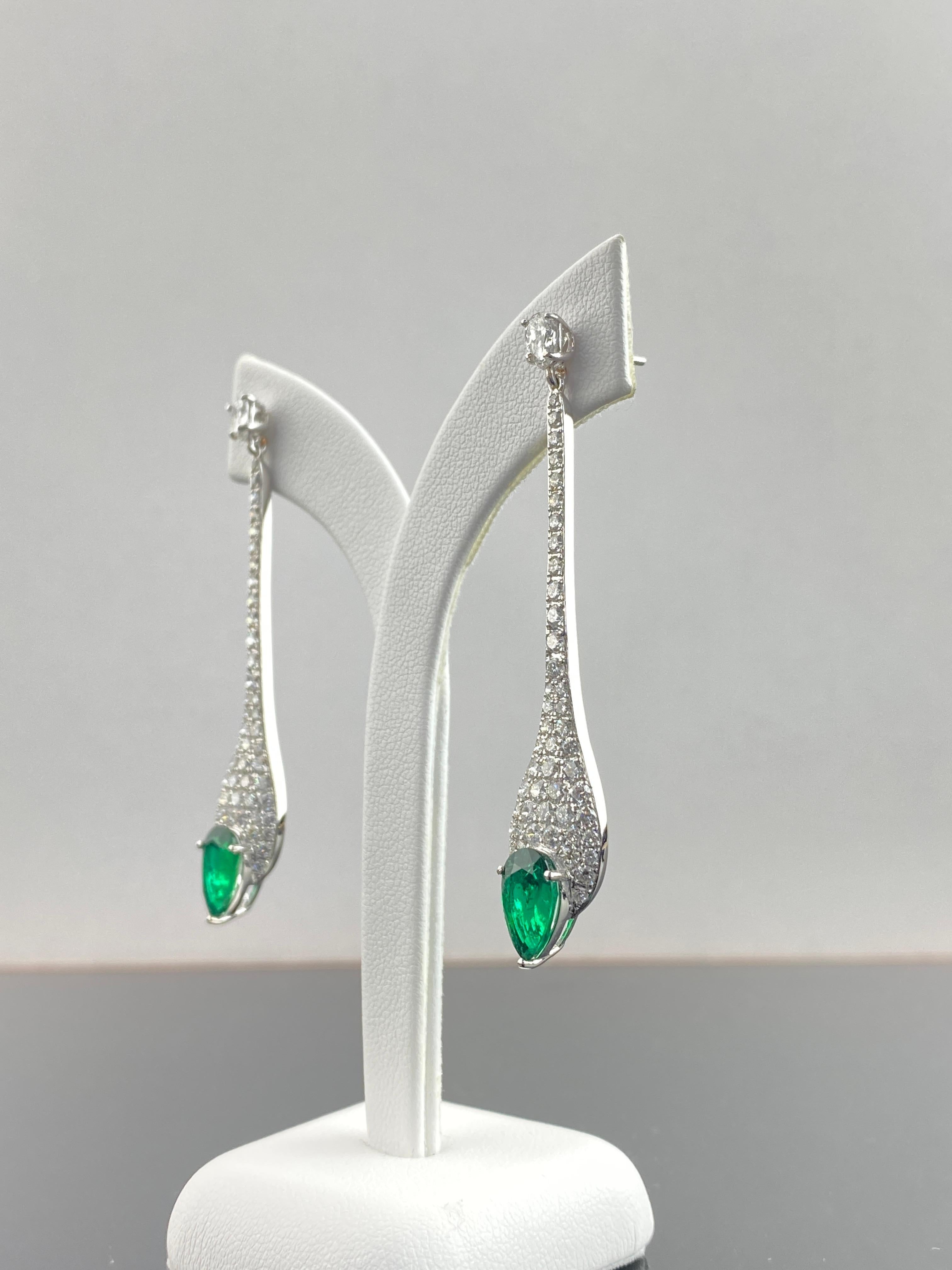 Un paio di elegantissimi orecchini pendenti con diamante da 3,28 carati e smeraldo dello Zambia a forma di pera da 3,03 carati, incastonati in oro bianco massiccio 18 carati. Gli orecchini hanno un bel design moderno e diamanti a forma di pera di