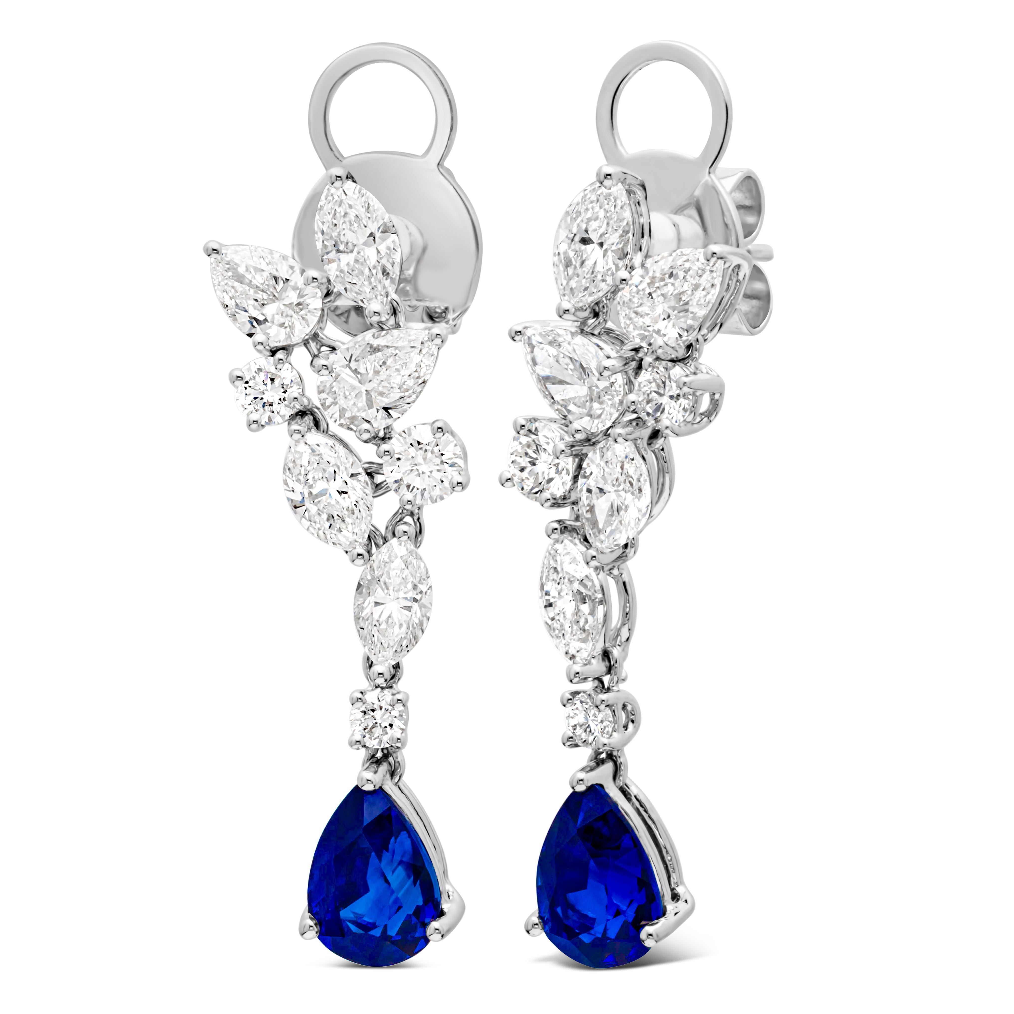 A sophisticated dangle earrings featuring a pear shape blue sapphire weighing 3.03 carats total, Elegantly set in a classic three prong basket setting and suspended on a cluster of pear, marquis and round shape diamonds weighing 3.13 carats total.